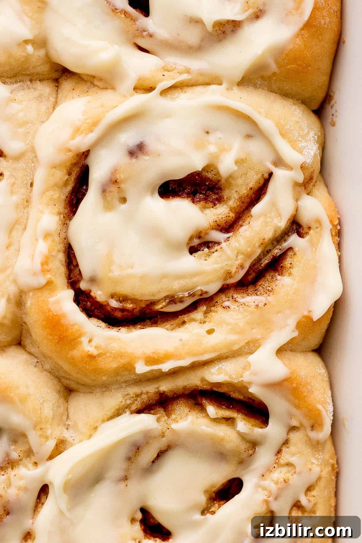 Brown Butter Banana Bread Cinnamon Rolls Recipe 6 Cinnamon rolls in a baking dish with icing.
