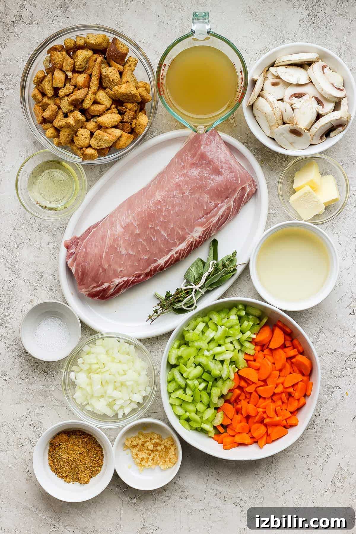 Ham, carrots, mushrooms and other ingredients in white bowls on a white background.