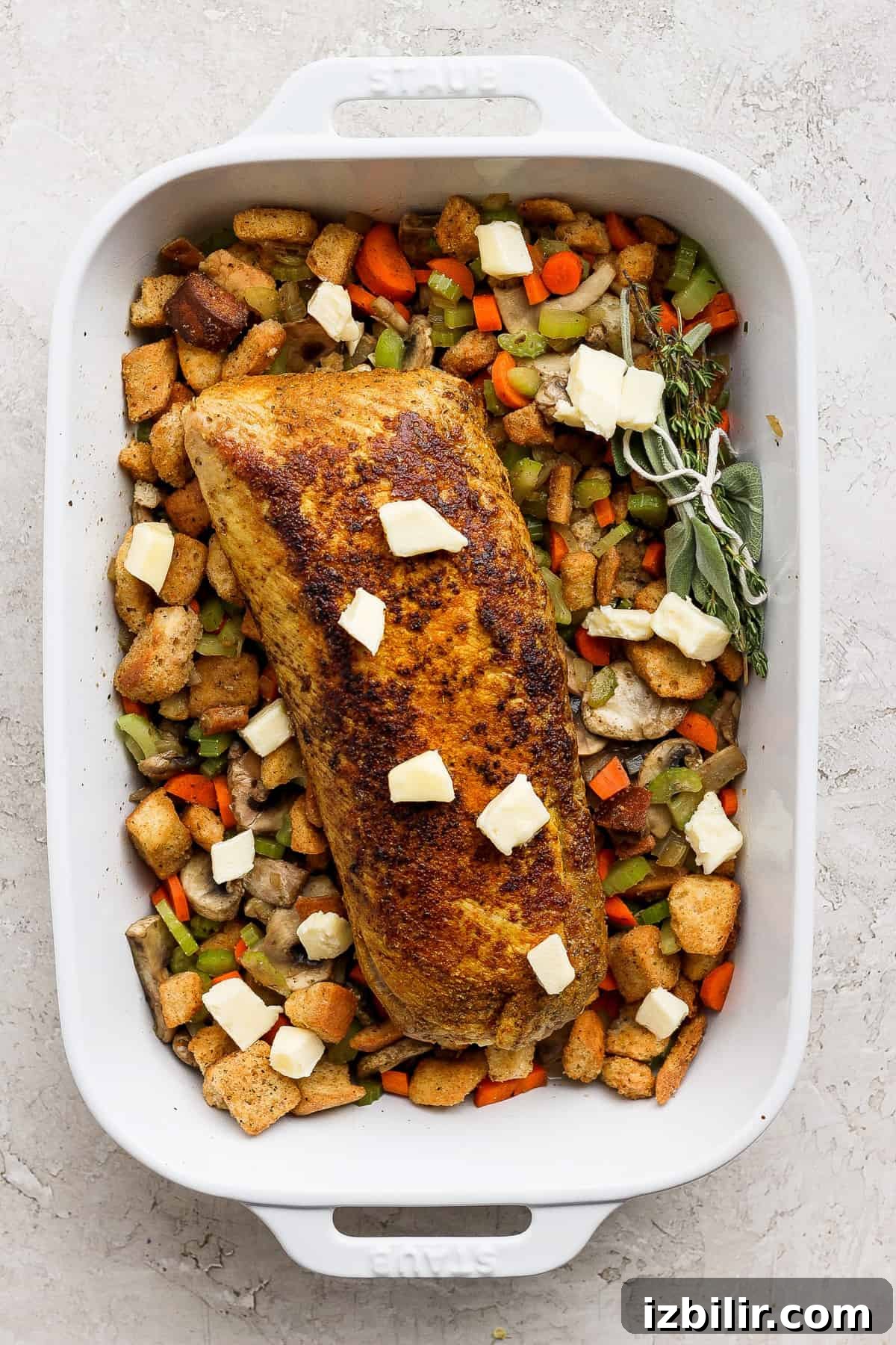 A white baking dish filled with chicken and vegetables.