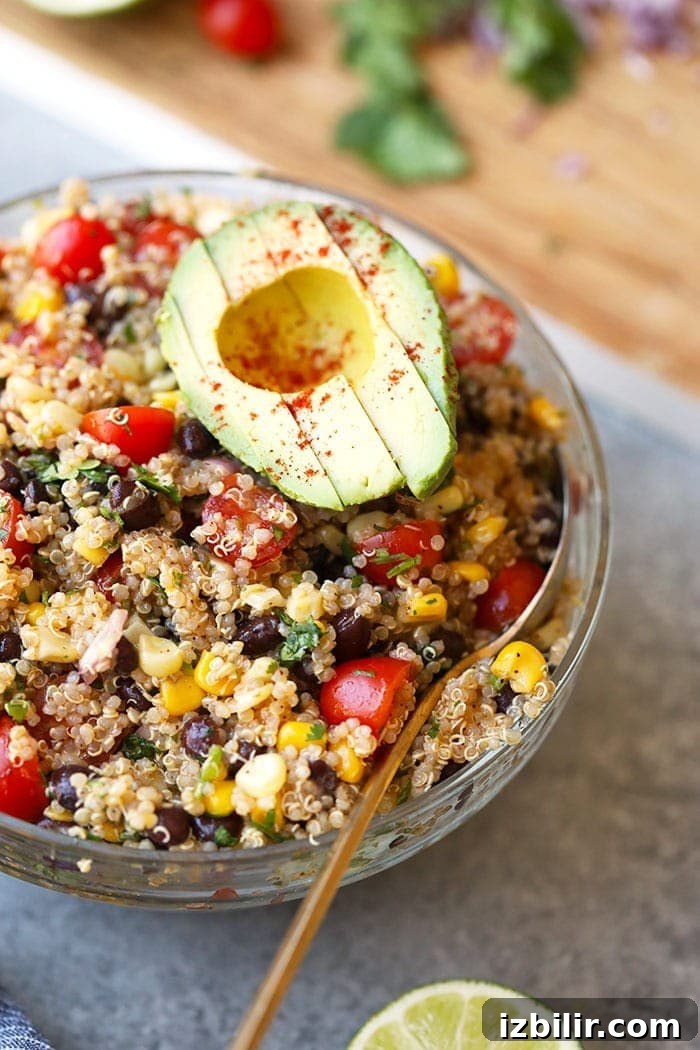 Quinoa salad is a favorite, healthy lunch idea. This Mexican Quinoa Salad recipe is packed with veggies, beans, and is high-protein! southwest quinoa salad in bowl with avocado