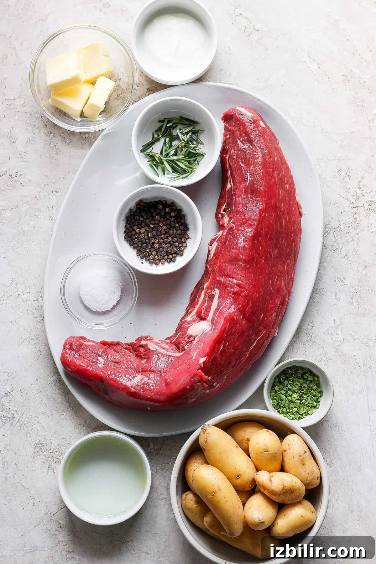 A plate with a piece of meat, potatoes and other ingredients.