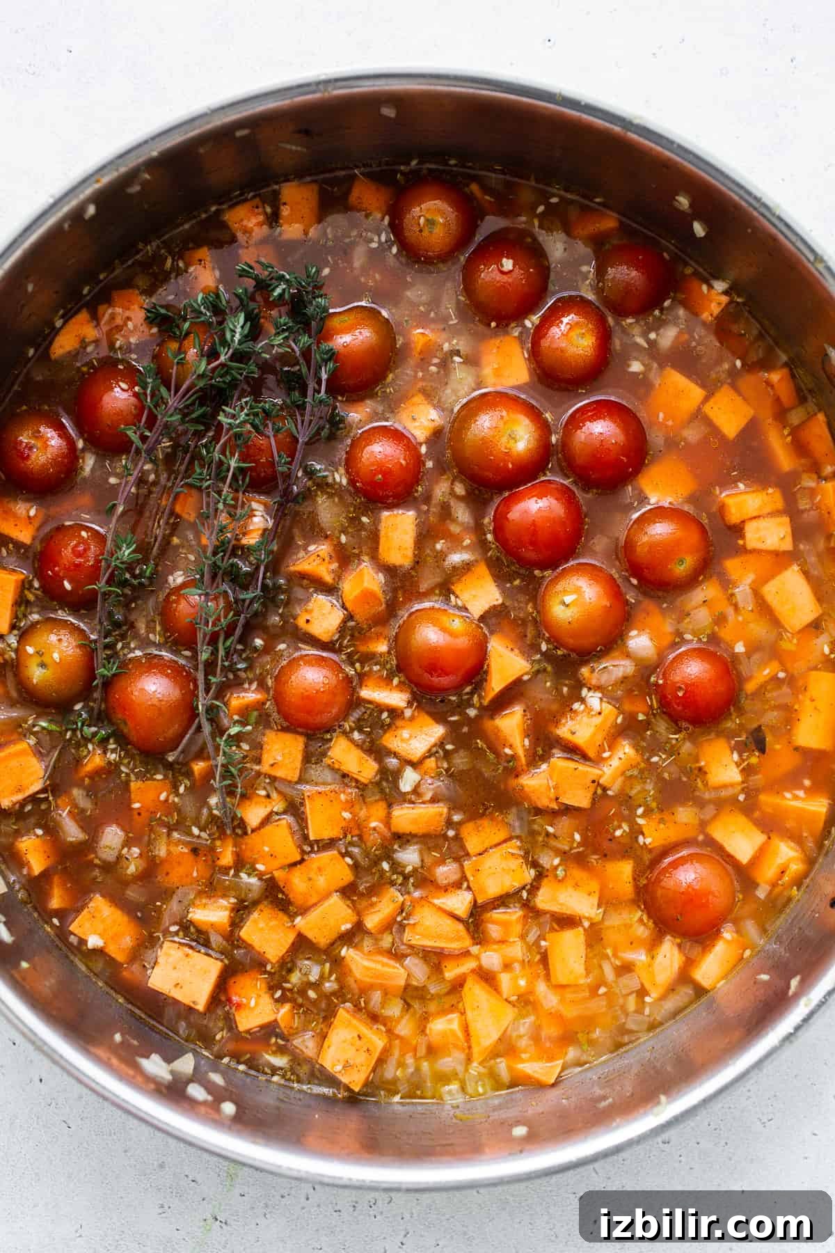 Roasted Sweet Potato and Mushroom Grain Bowl Recipe 3 A pan filled with tomatoes and a sprig of thyme.
