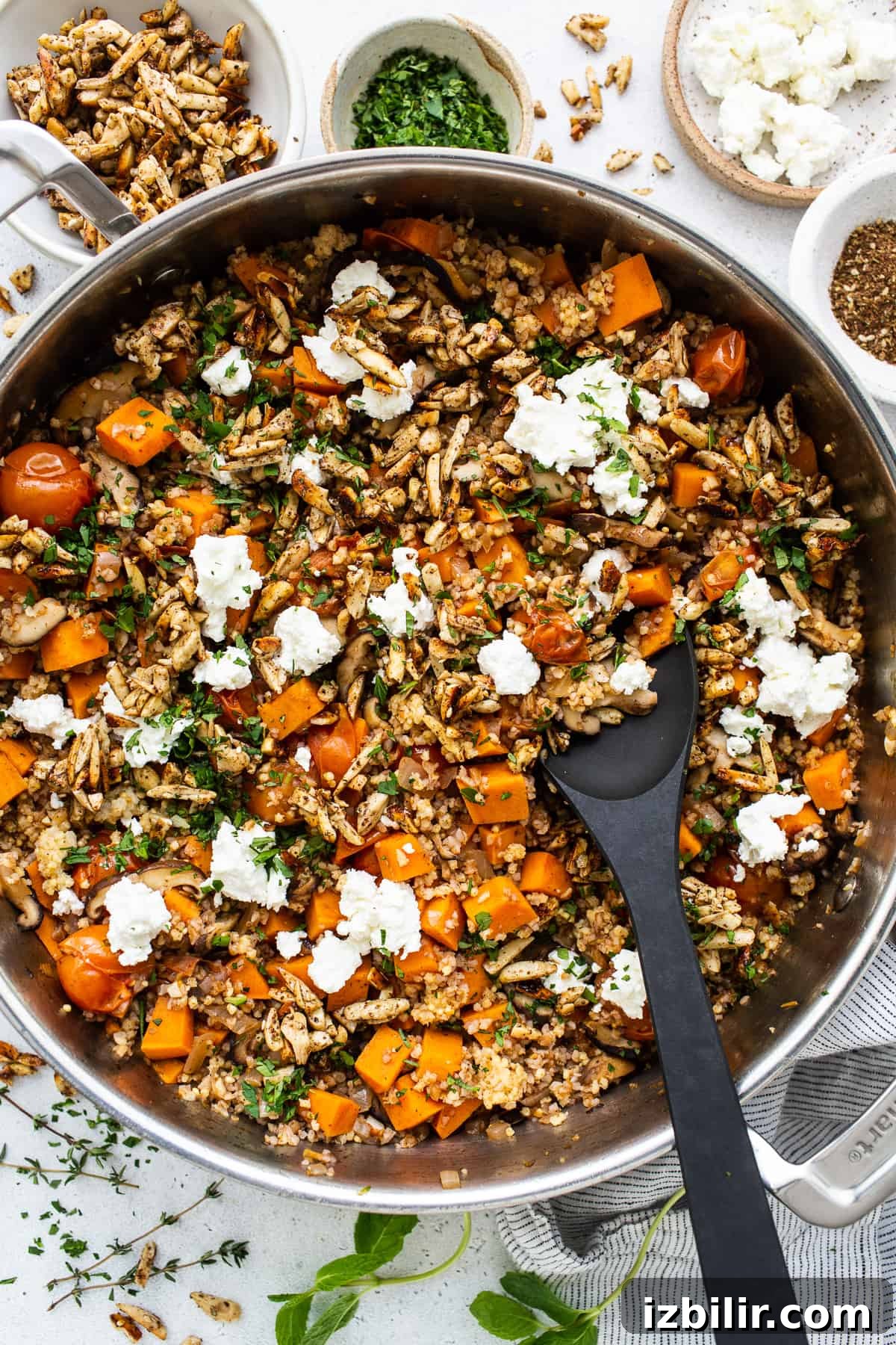 Roasted Sweet Potato and Mushroom Grain Bowl Recipe 4 A skillet filled with vegetables and feta cheese.