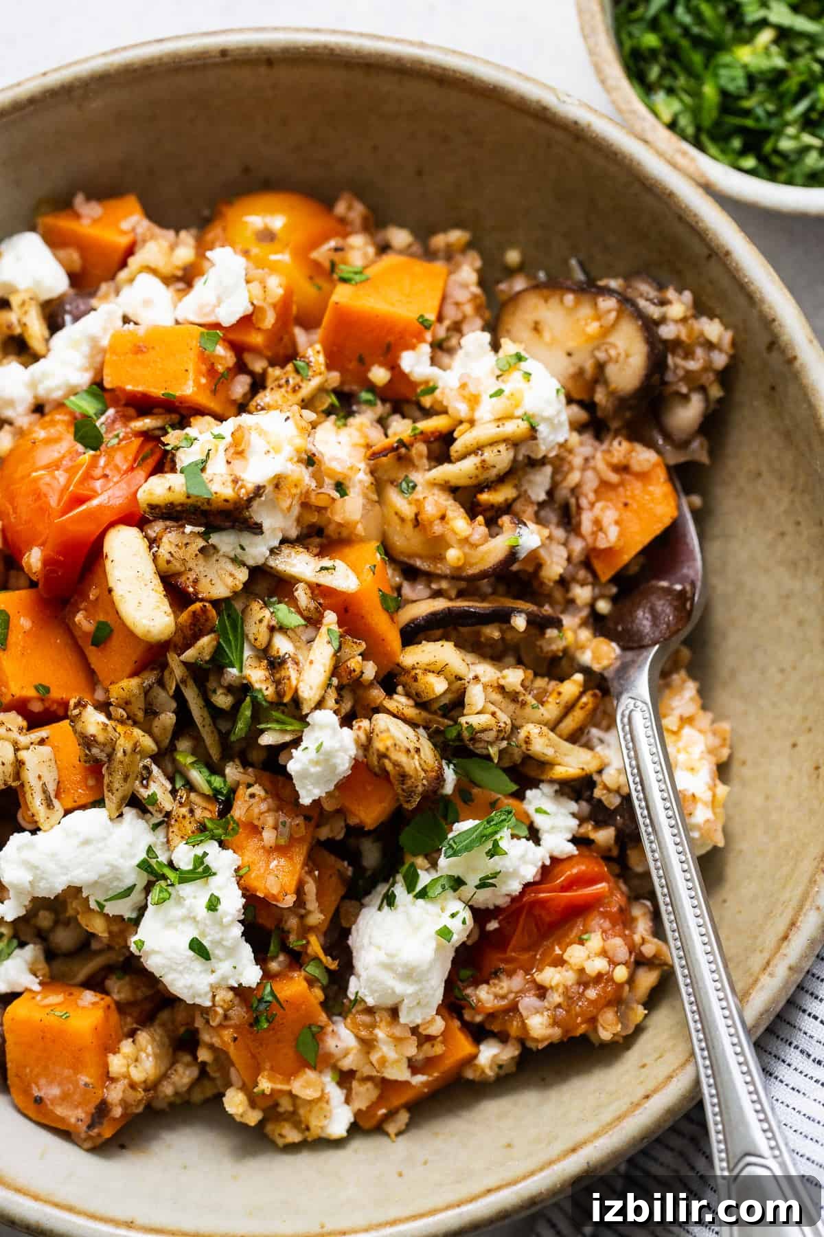Roasted Sweet Potato and Mushroom Grain Bowl Recipe 5 A bowl filled with quinoa, squash and feta.