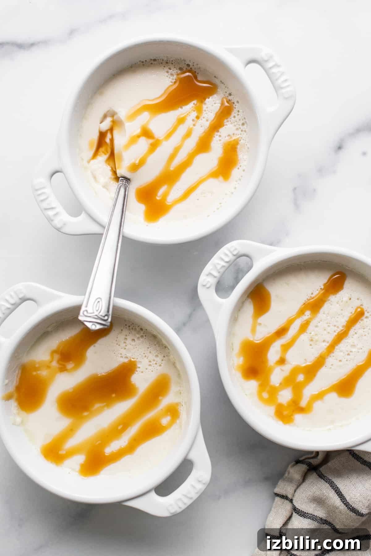 Three white bowls with caramel sauce on them.