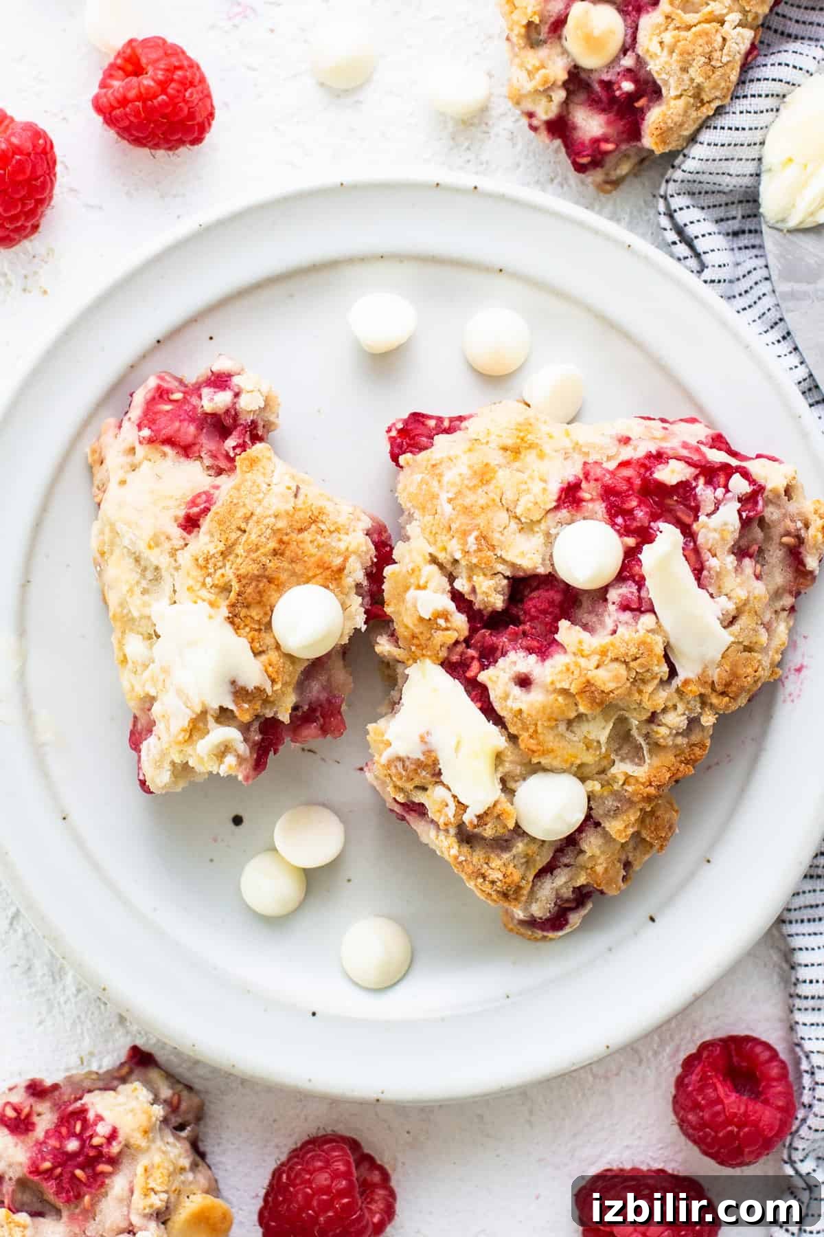 Raspberries and white chocolate scones on a plate.
