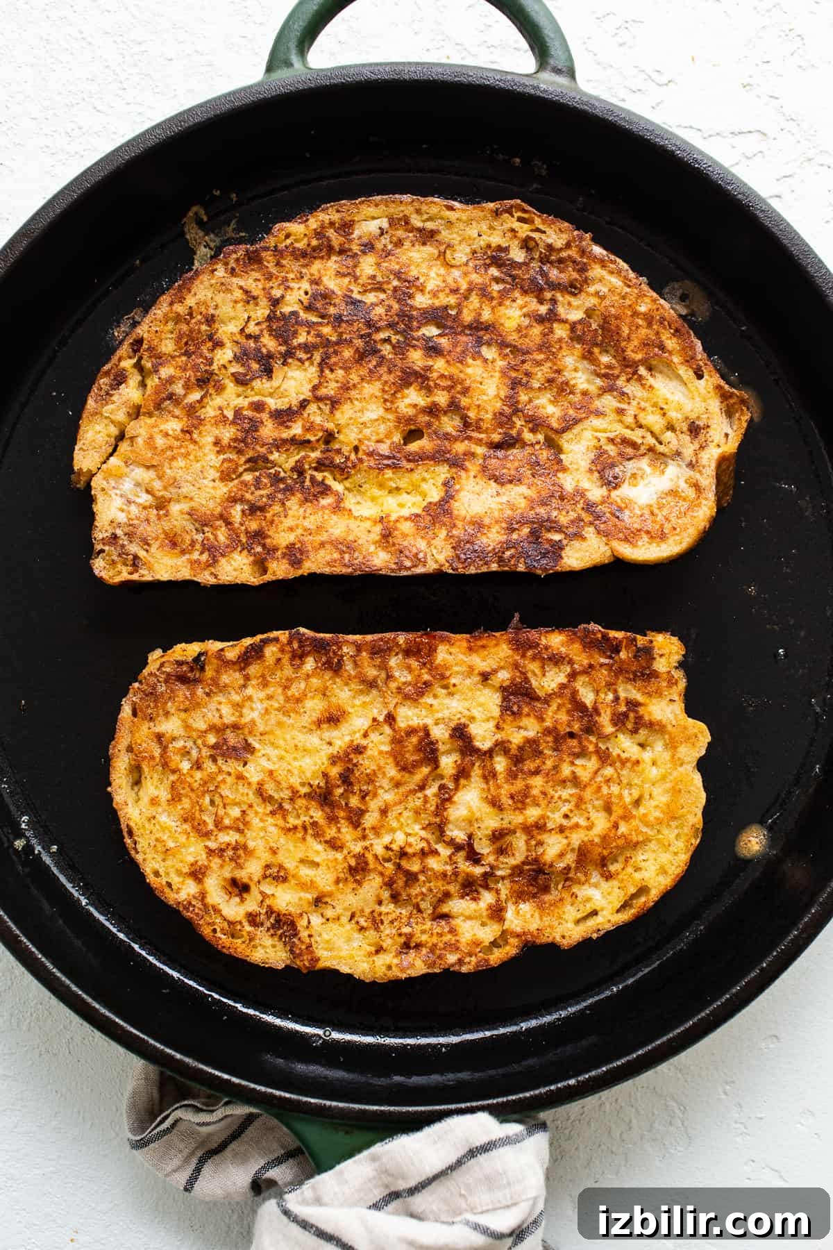Caramelized Bananas Foster French Toast with Rum Sauce 3 Two slices of french toast in a skillet.