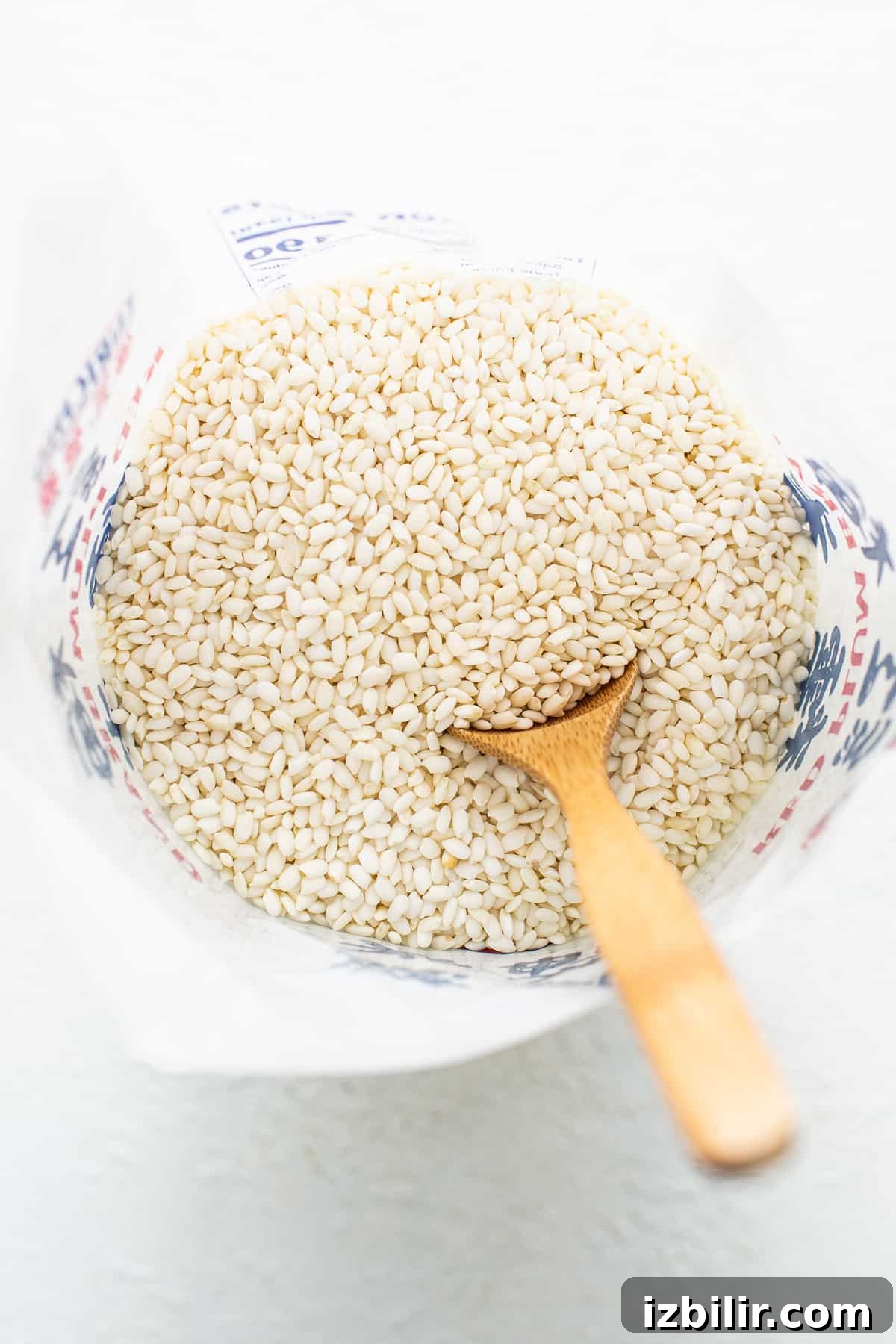 Buckwheat groats in a bowl with a wooden spoon.