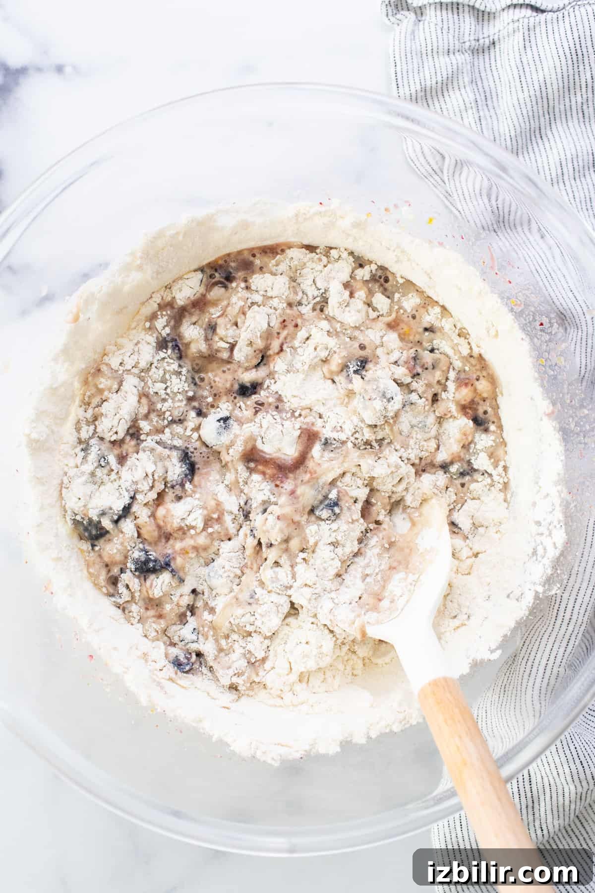 A bowl of oats with a wooden spoon in it.