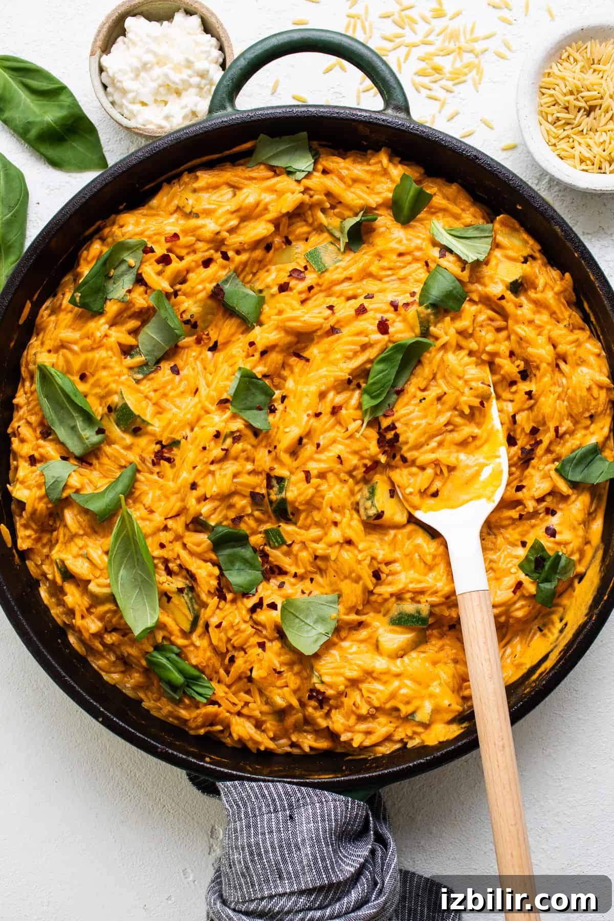 One-Pot Creamy Tomato Orzo with Fresh Basil 2 A skillet filled with mashed potatoes and herbs.