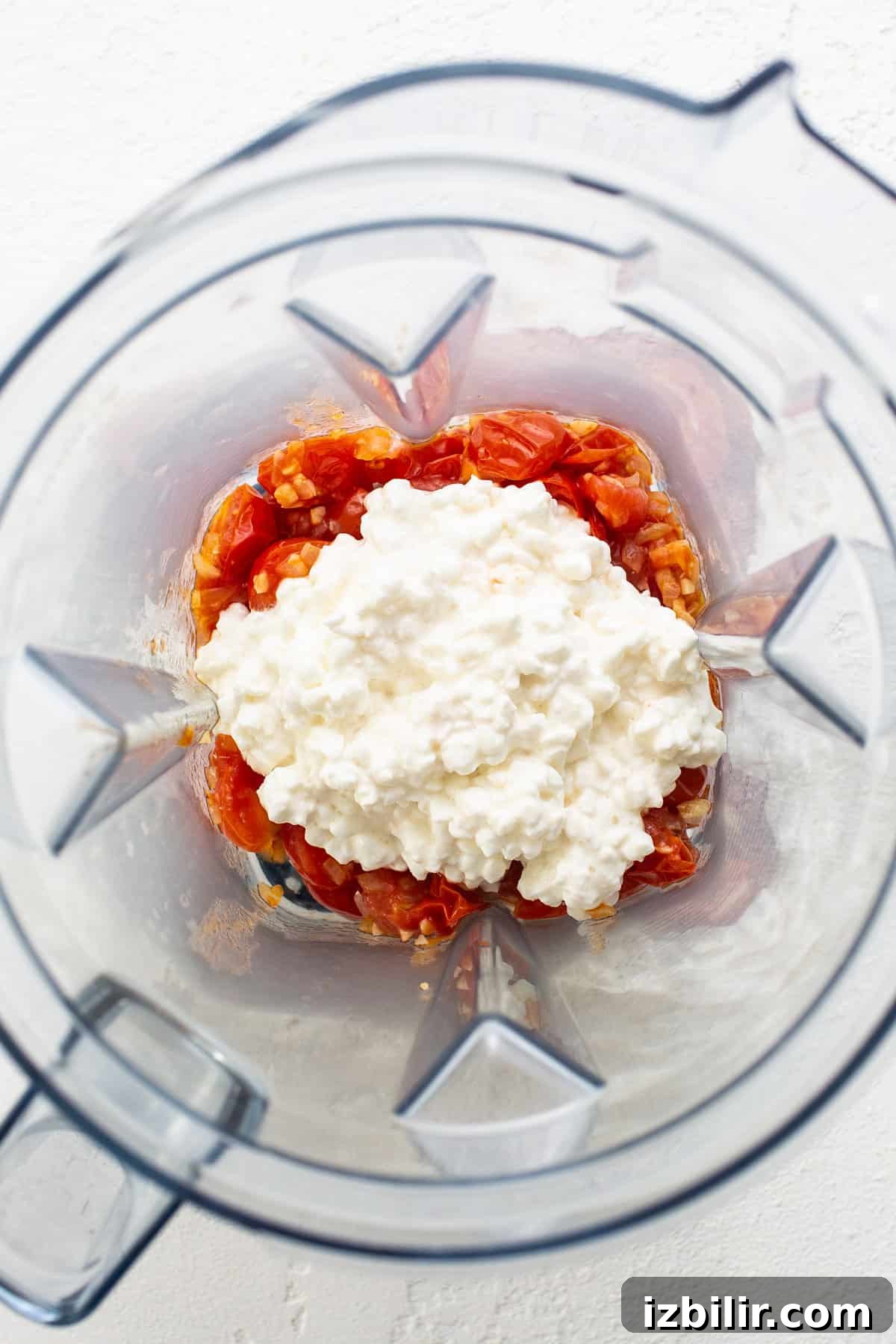 One-Pot Creamy Tomato Orzo with Fresh Basil 4 A blender filled with tomatoes and feta cheese.