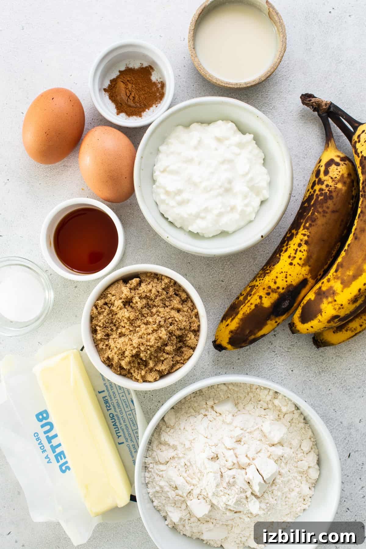 Ingredients for banana bread including bananas, flour, eggs and butter.