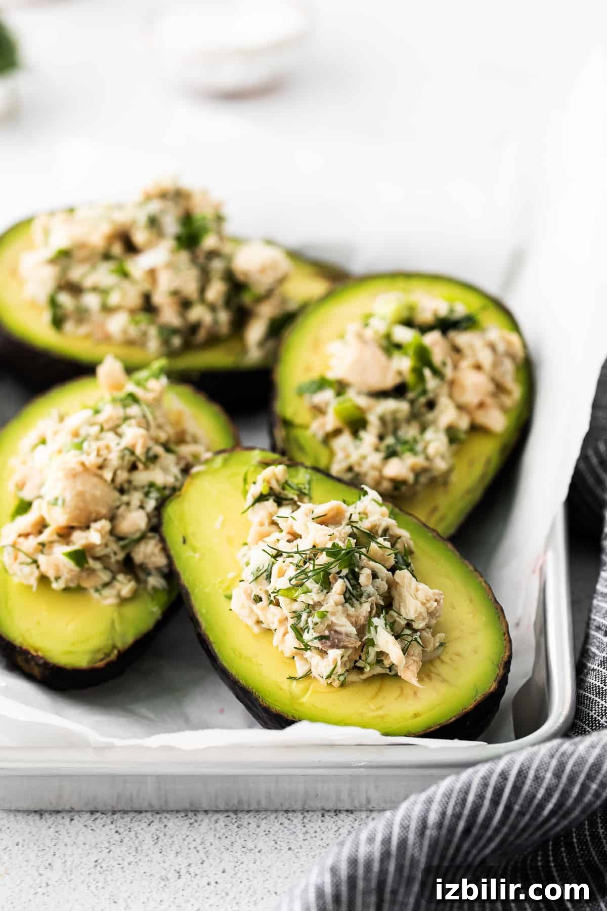 Salmon Stuffed Avocados Recipe with Dill and Lemon 2 Stuffed avocado boats on a plate.