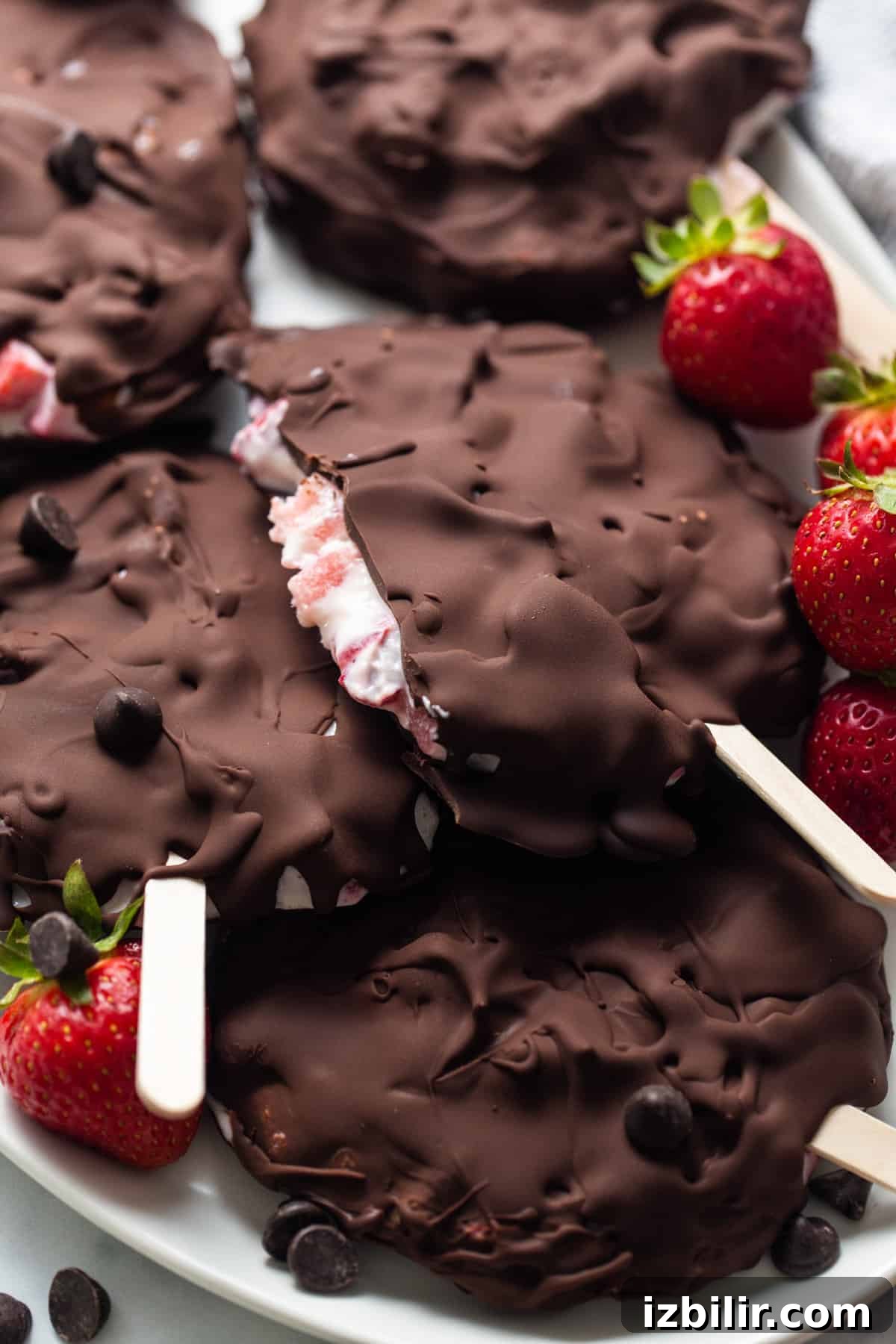 Chocolate-Dipped Strawberry Frozen Yogurt Bars 9 Chocolate covered strawberry popsicles on a plate.