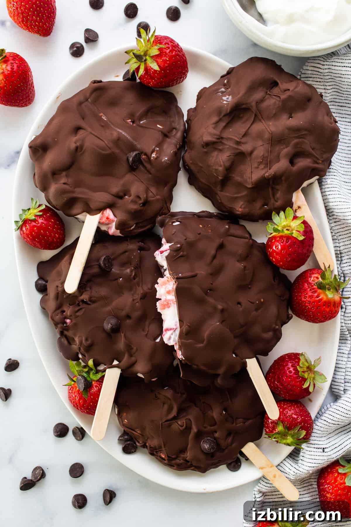 Chocolate-Dipped Strawberry Frozen Yogurt Bars 10 Chocolate covered strawberry popsicles on a plate.