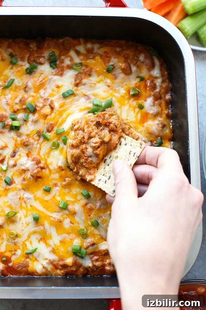 Make this winning chili cheese dip for the big game and your guests will gobble it up. It really is the best chili cheese dip recipe! chip scooping dip