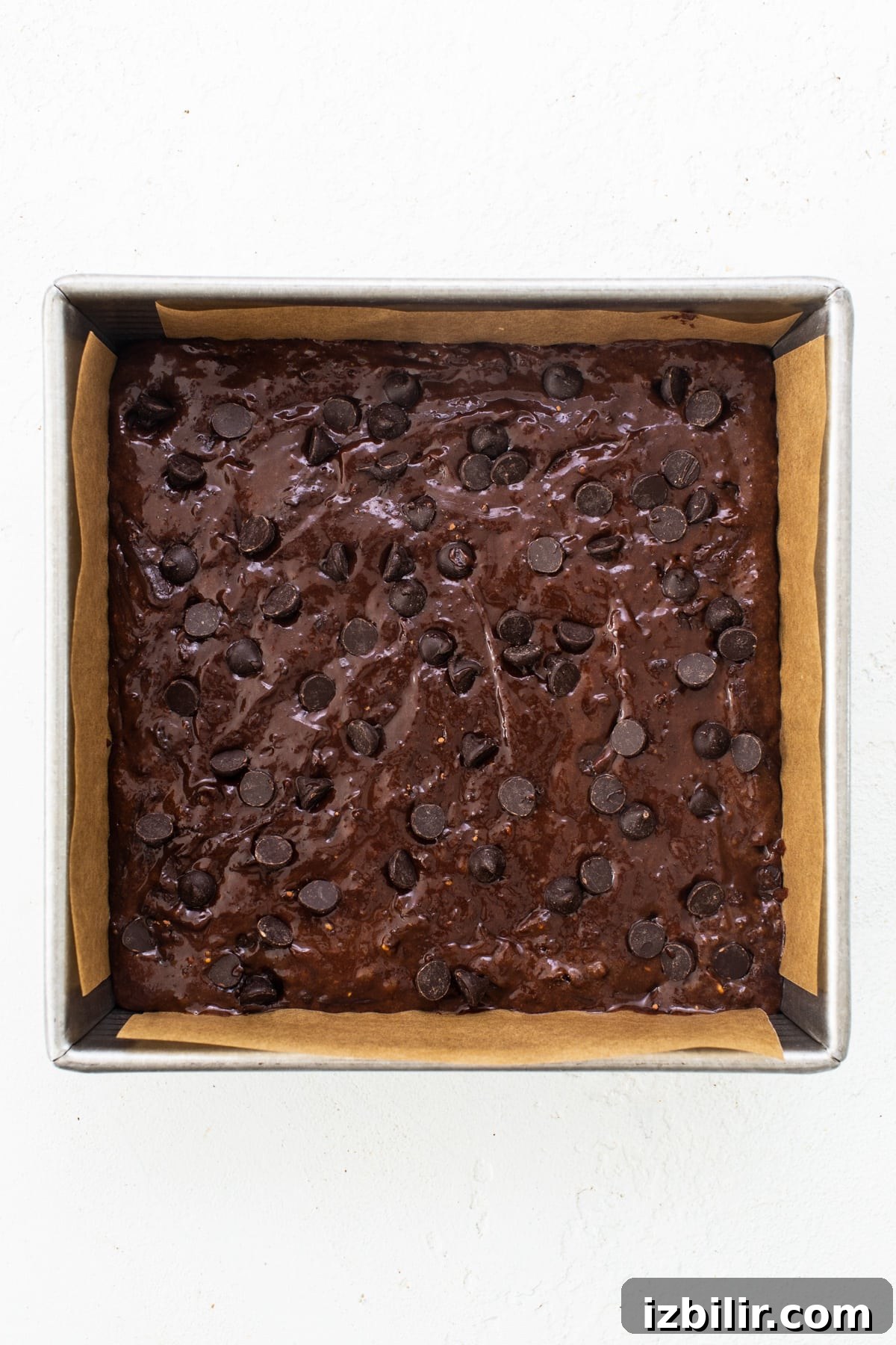 Flourless Peanut Butter Protein Brownies Recipe 5 A brownie in a baking pan with chocolate chips.