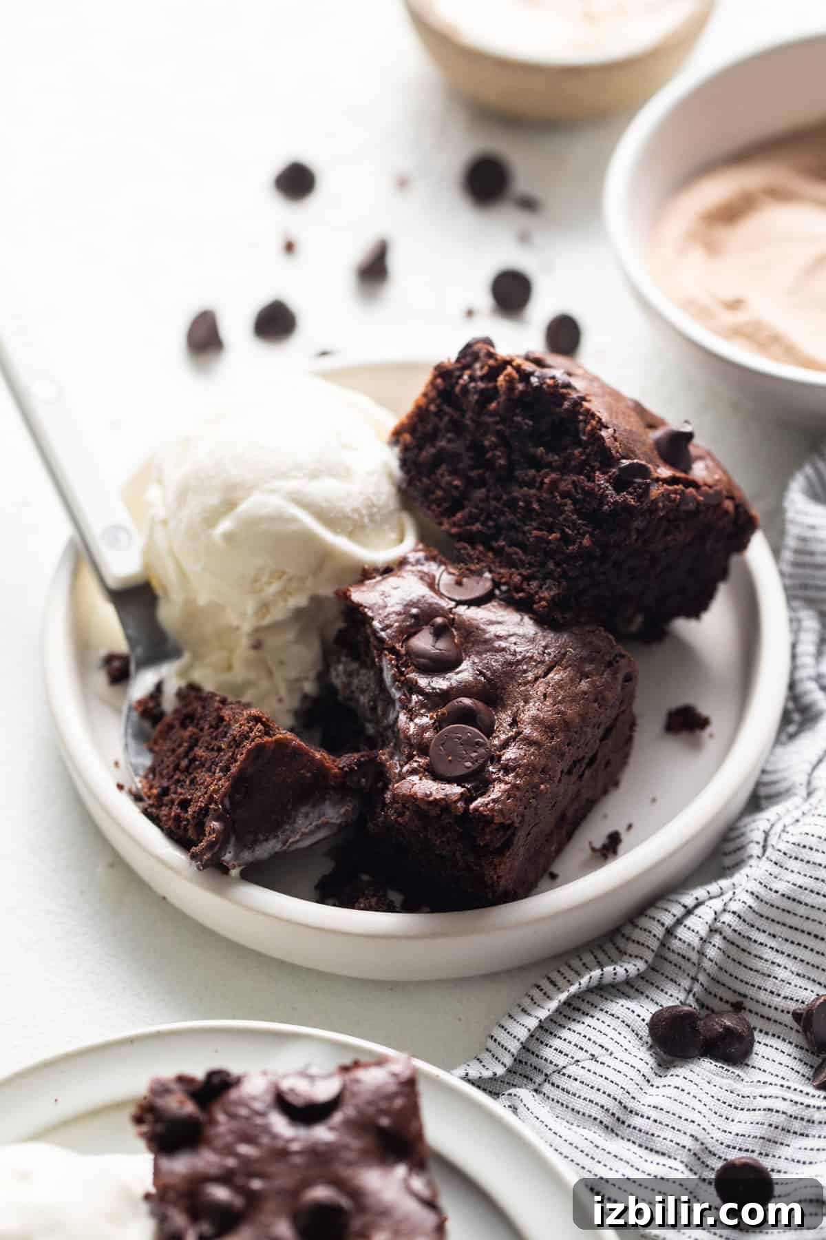 Flourless Peanut Butter Protein Brownies Recipe 6 A plate of chocolate brownies with ice cream and a scoop of ice cream.