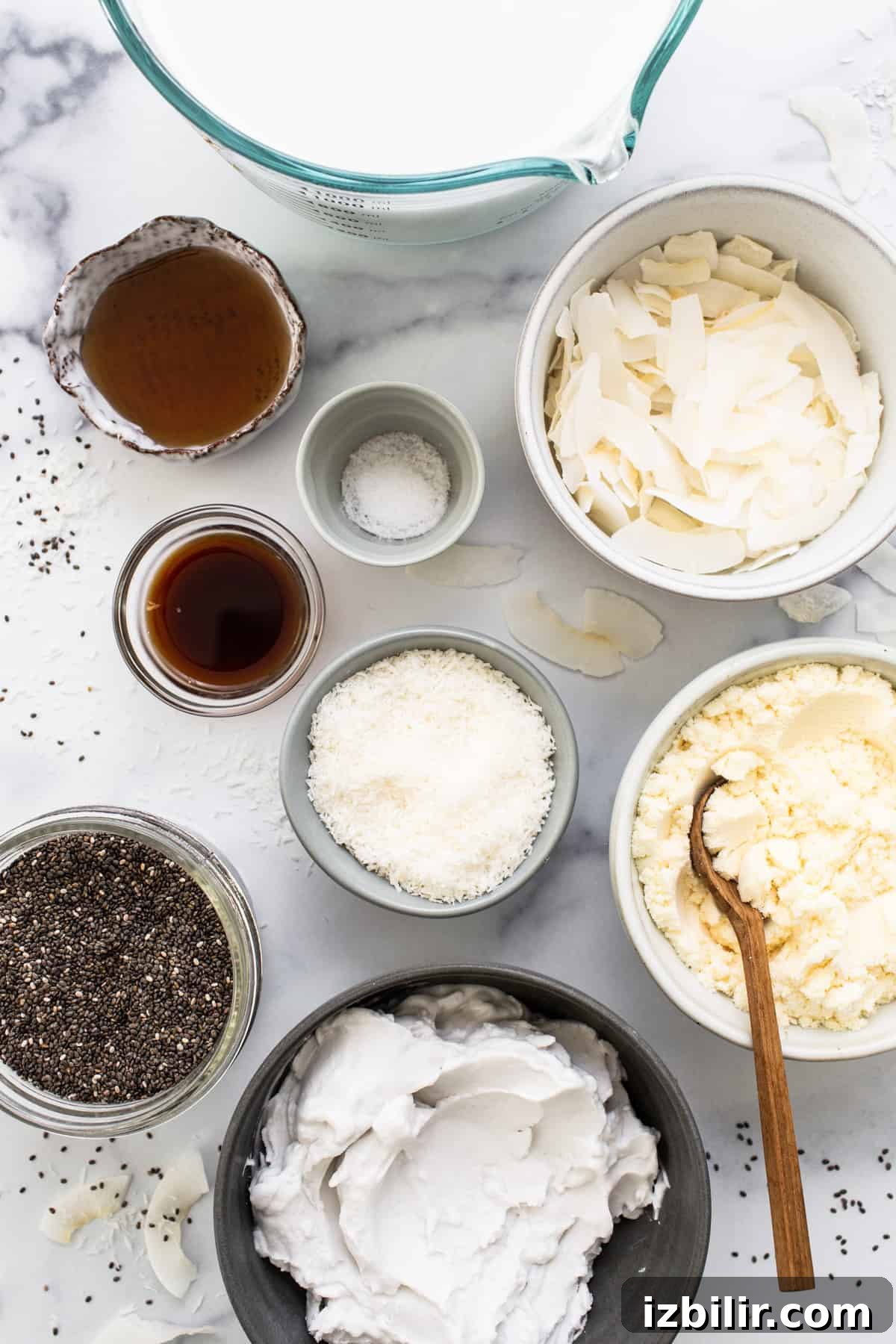 All the ingredients for a chia pudding in bowls on a marble table.