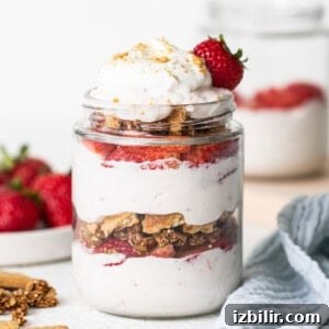 Strawberry Protein Cheesecake Jars with Cottage Cheese 8 A small jar of strawberry cheesecake with granola on top.