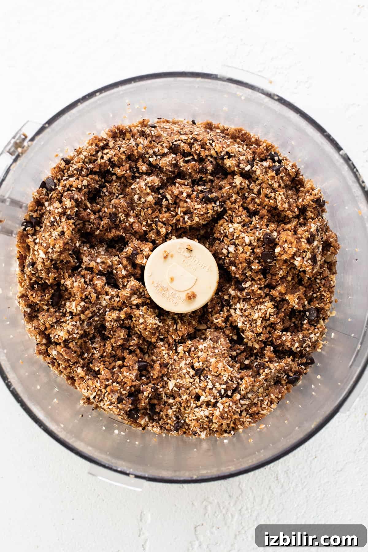 A food processor filled with granola and a banana.
