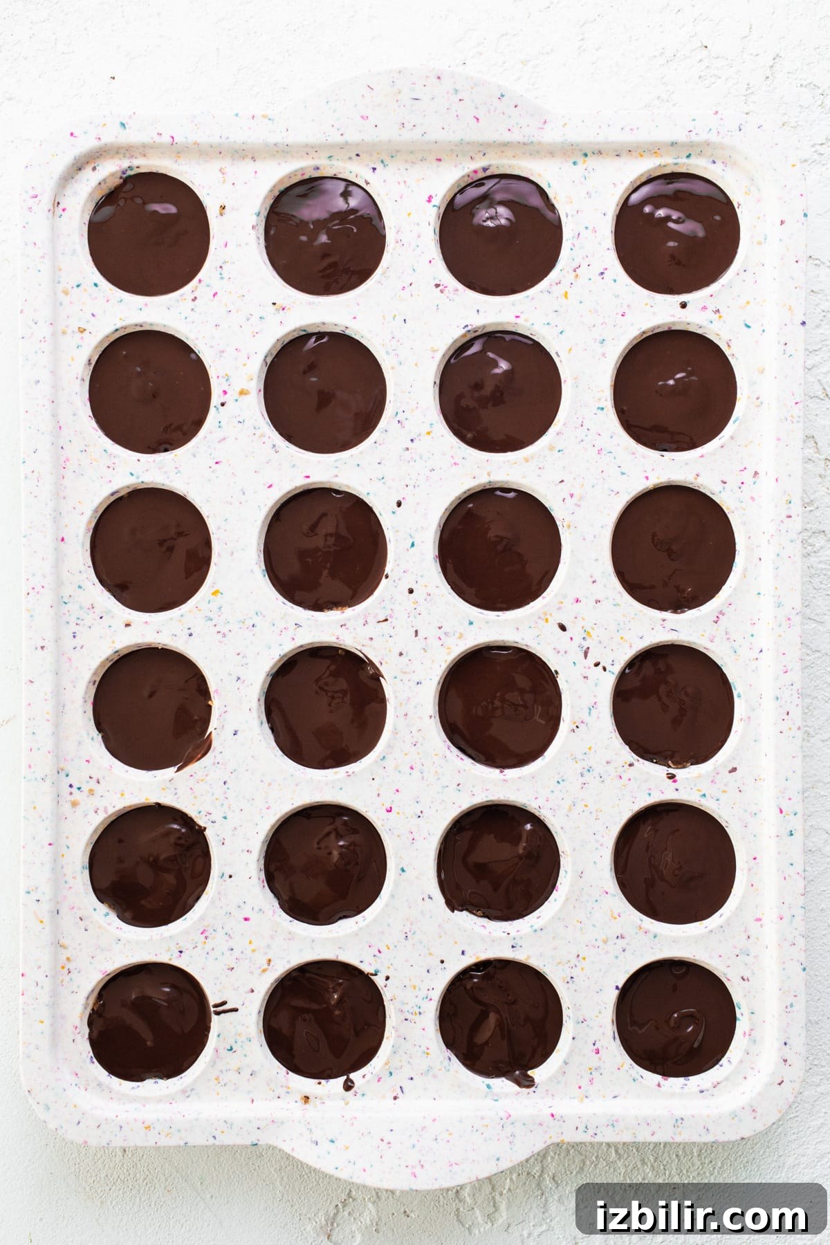 A tray filled with chocolate covered donuts.