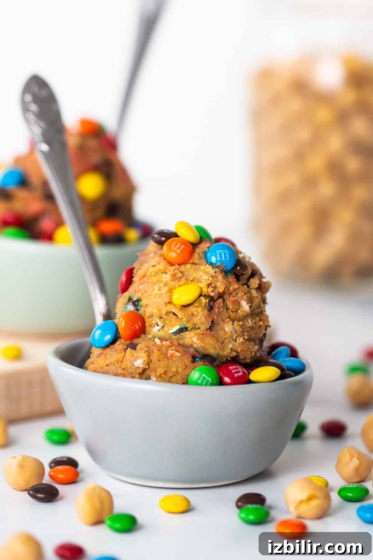 A bowl filled with m&m's and a spoon.