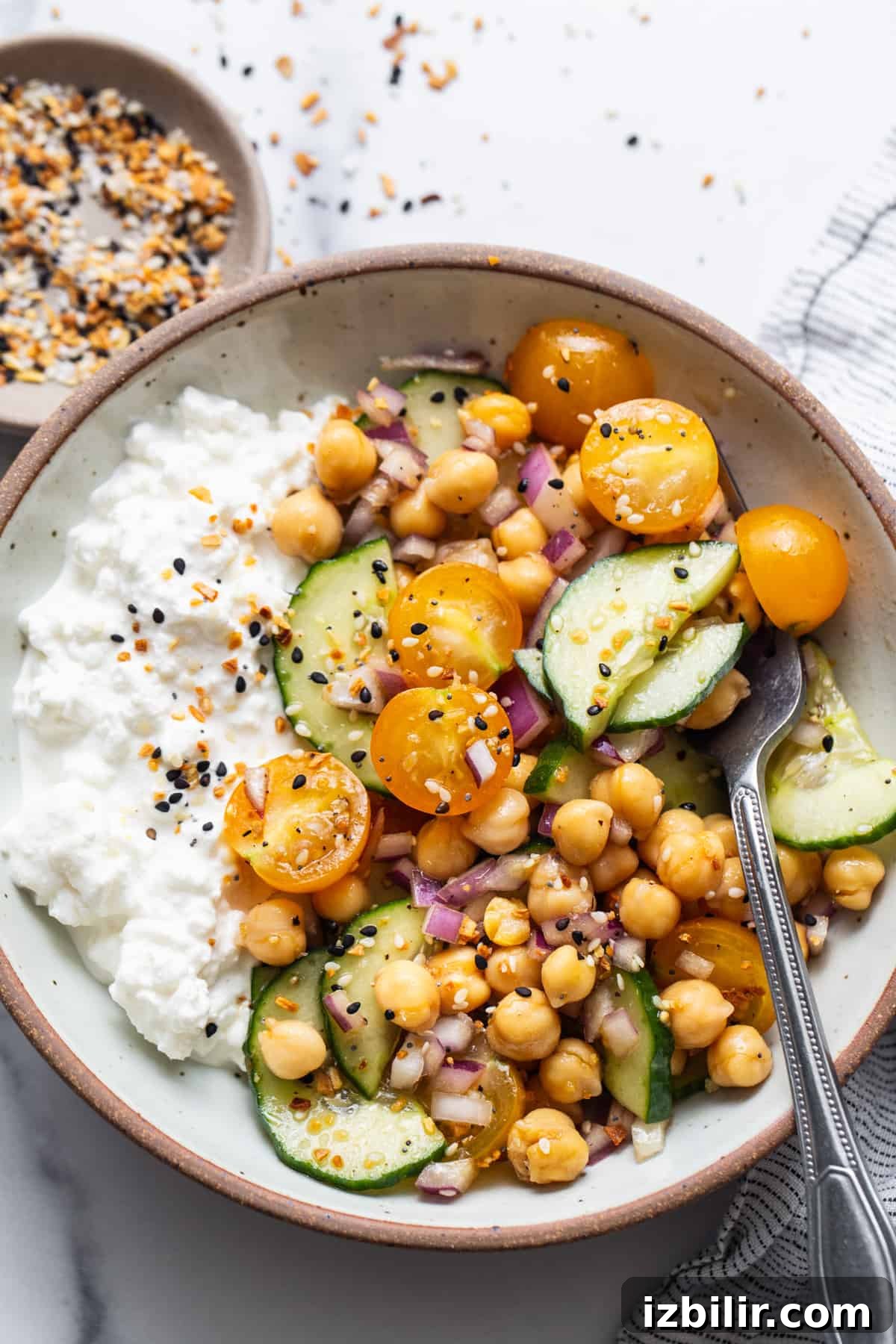 A bowl with chickpeas, cucumber and rice.