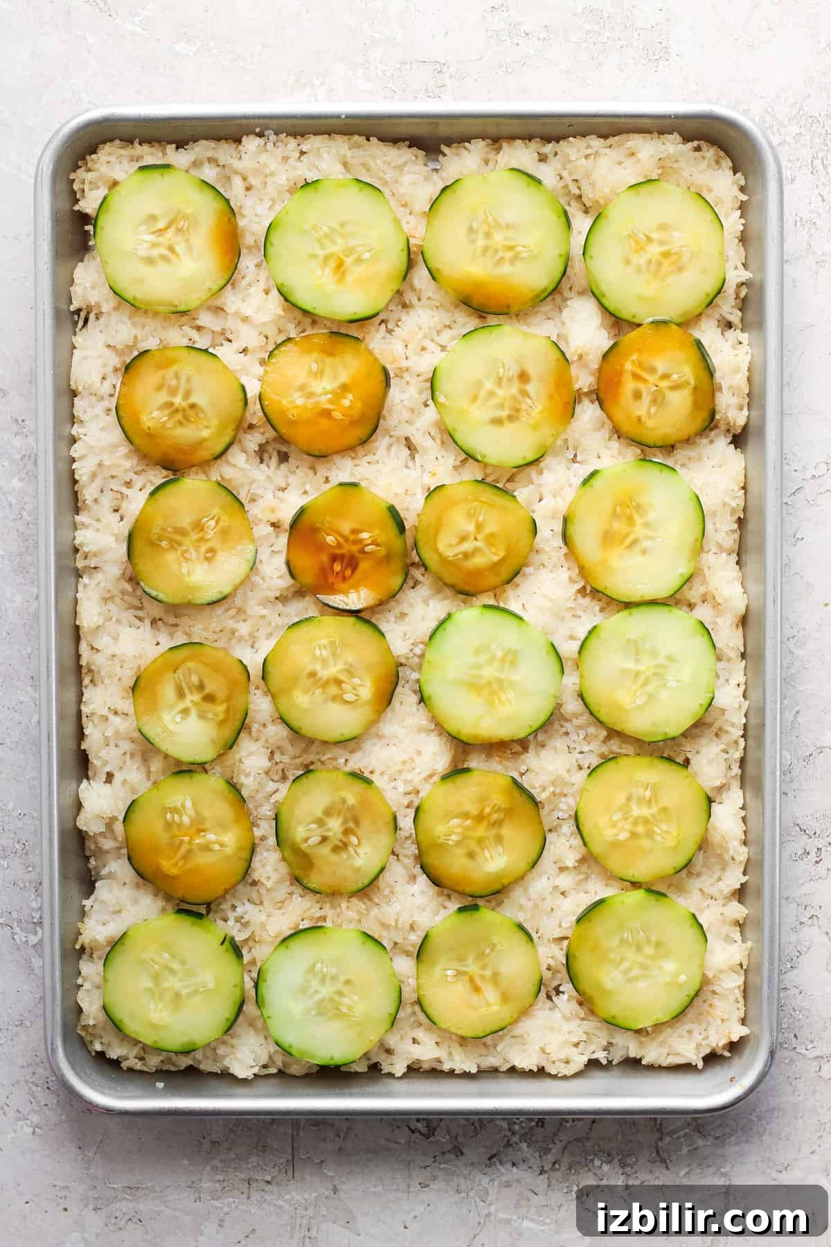 Sheet-Pan Salmon with Crispy Golden Rice 5 Baking pan with rice and cucumber slices