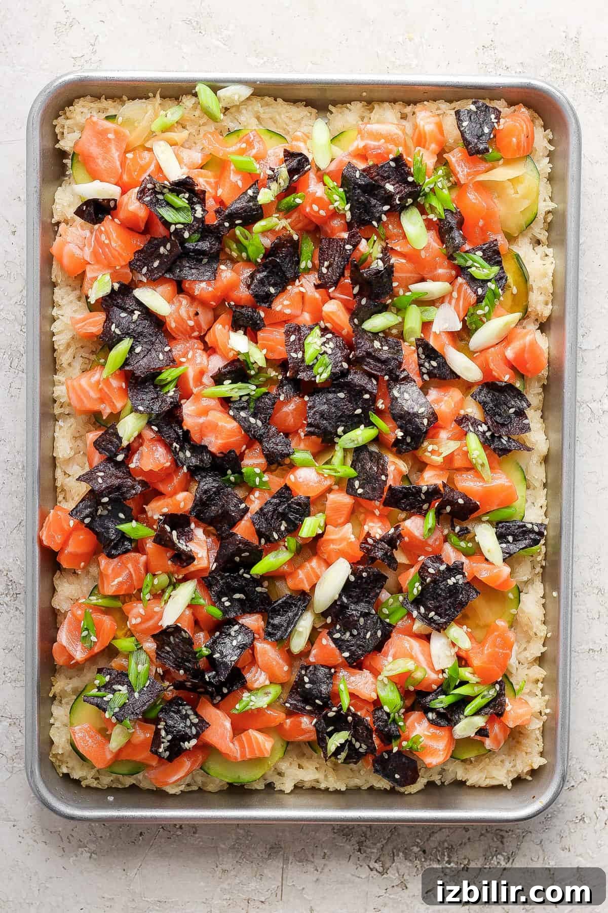 Sheet-Pan Salmon with Crispy Golden Rice 7 Crispy rice with salmon and onions on a pan
