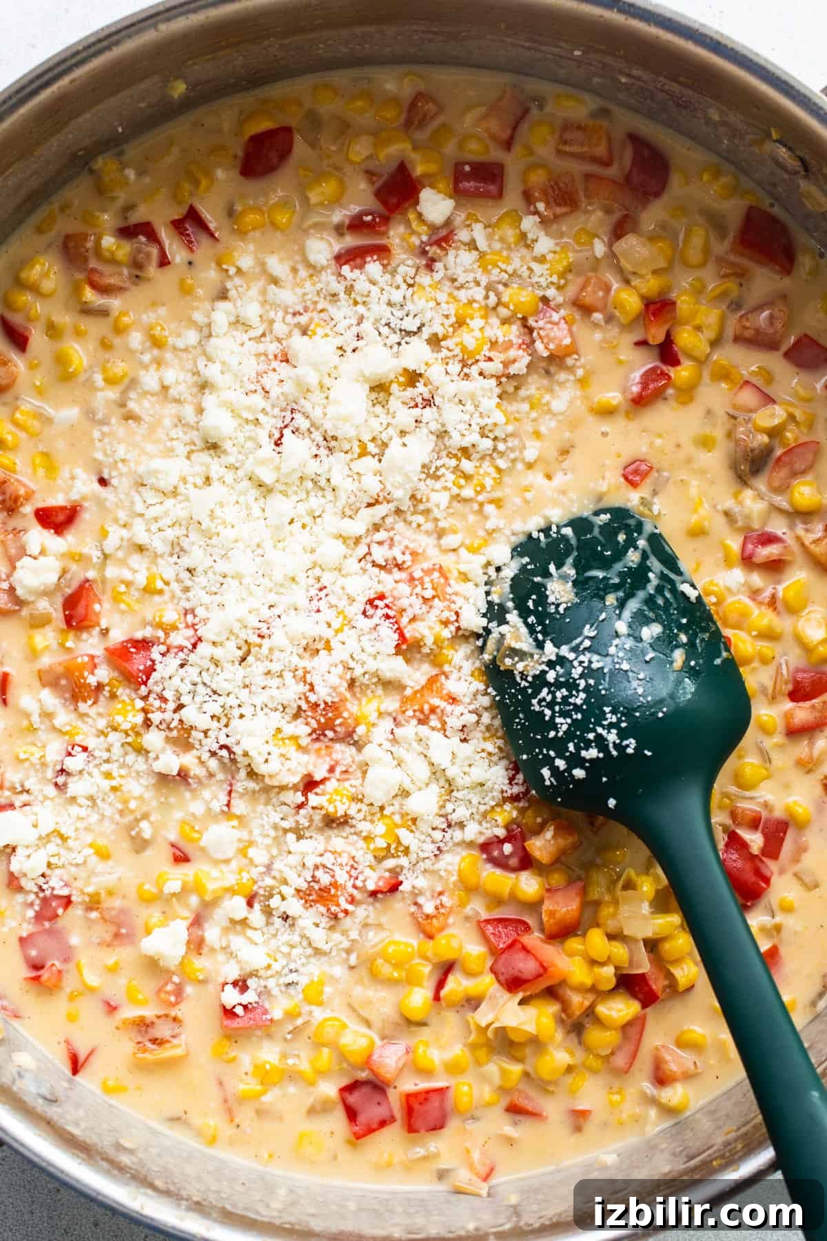 Stovetop Creamy Street Corn Chicken Skillet 4 Corn chowder in a pan with a green spatula.