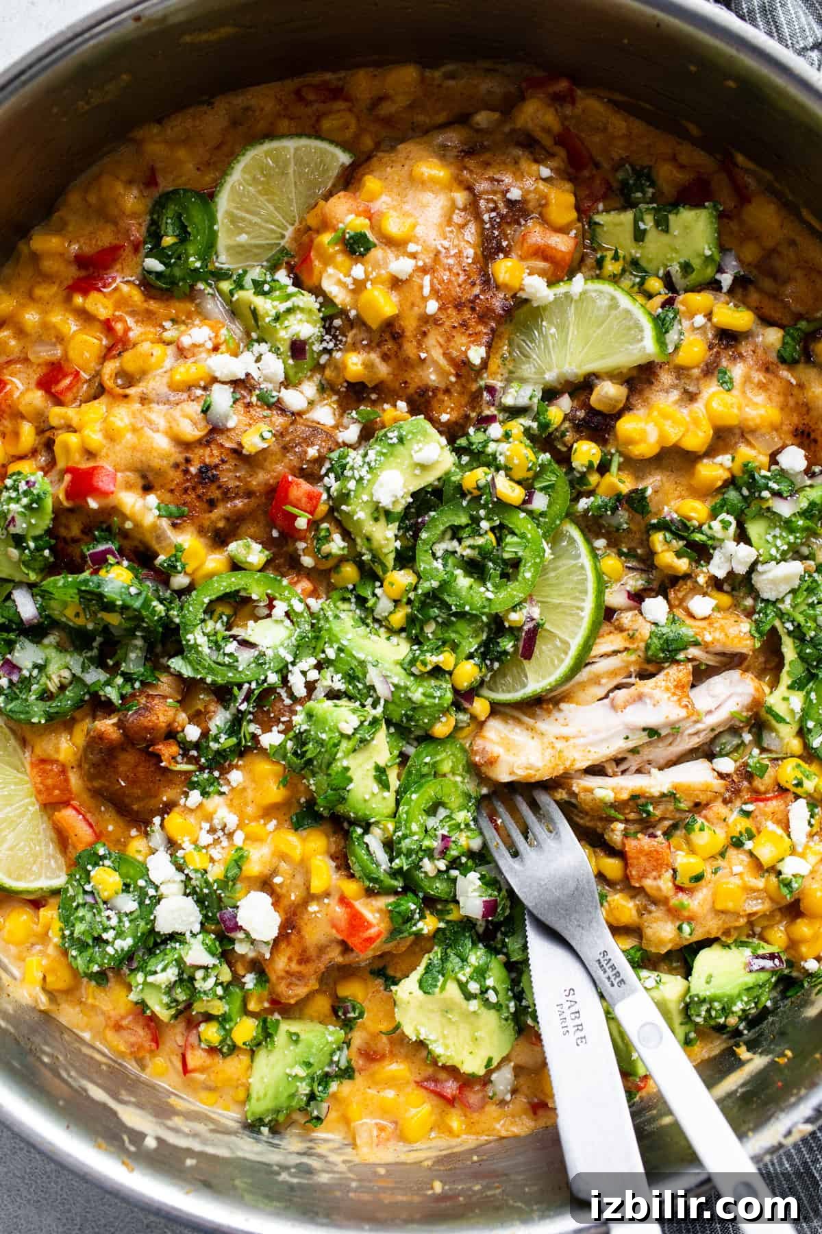 Stovetop Creamy Street Corn Chicken Skillet 5 A pan with chicken, corn and vegetables in it.