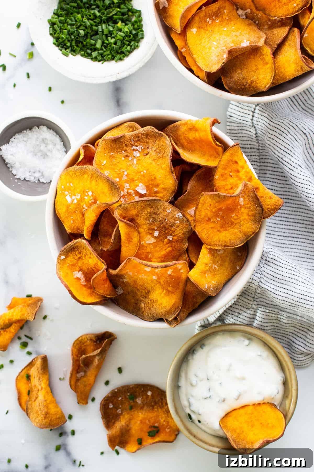 A bowl of sweet potato chips with dipping sauce.