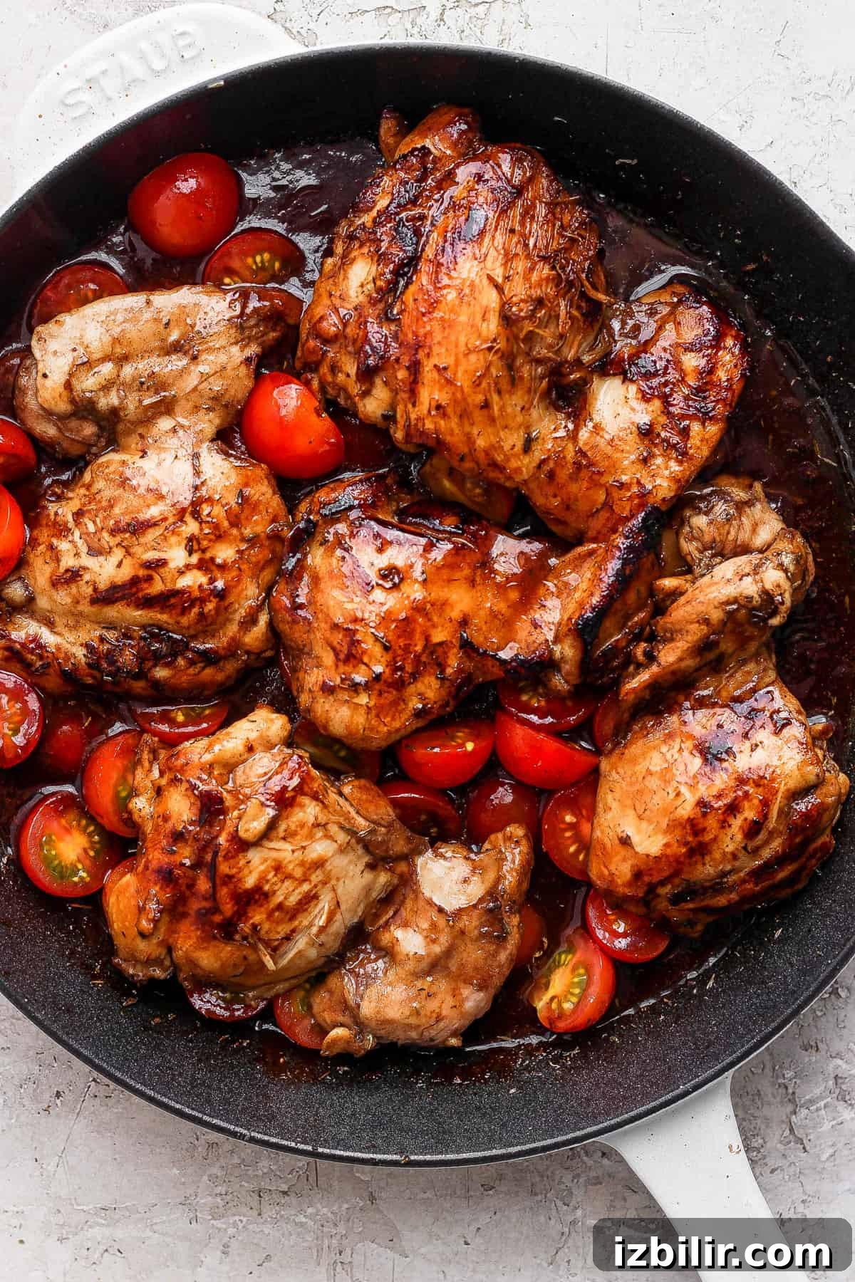 Sticky Balsamic Chicken Thighs with Garlic 5 Grilled chicken in a skillet with tomatoes.