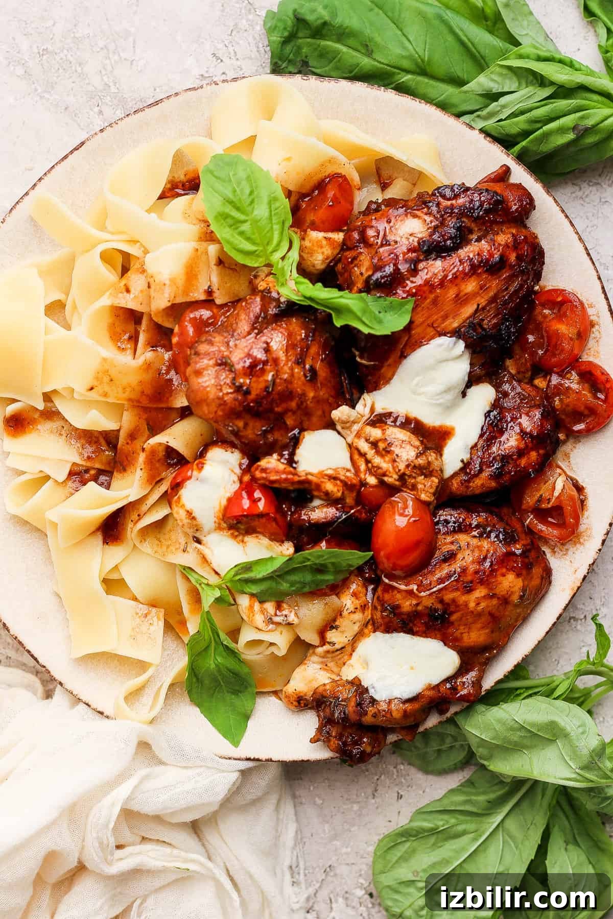Sticky Balsamic Chicken Thighs with Garlic 8 A plate of pasta with chicken, tomatoes and basil.
