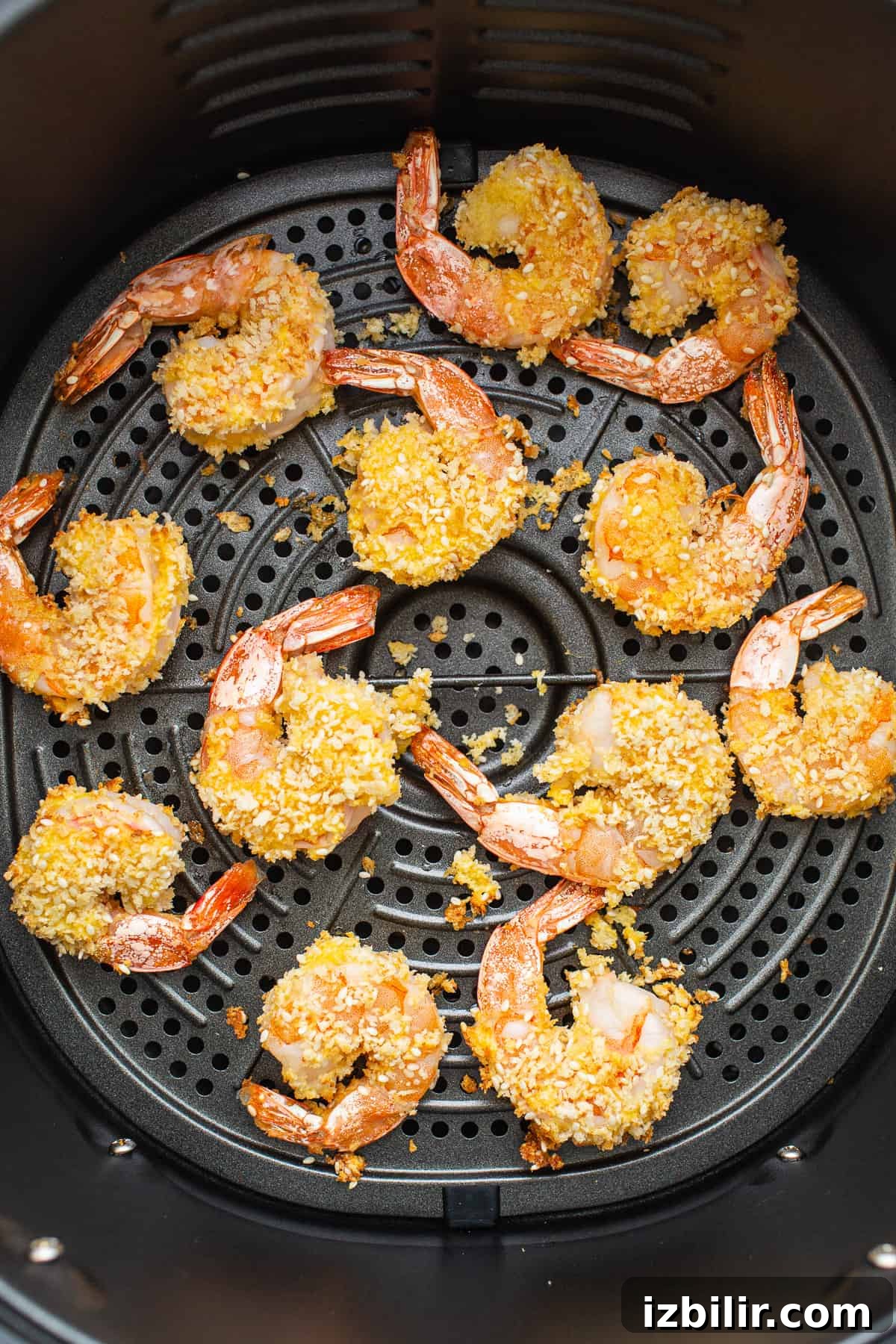 Fried shrimp in an air fryer with sesame seeds.