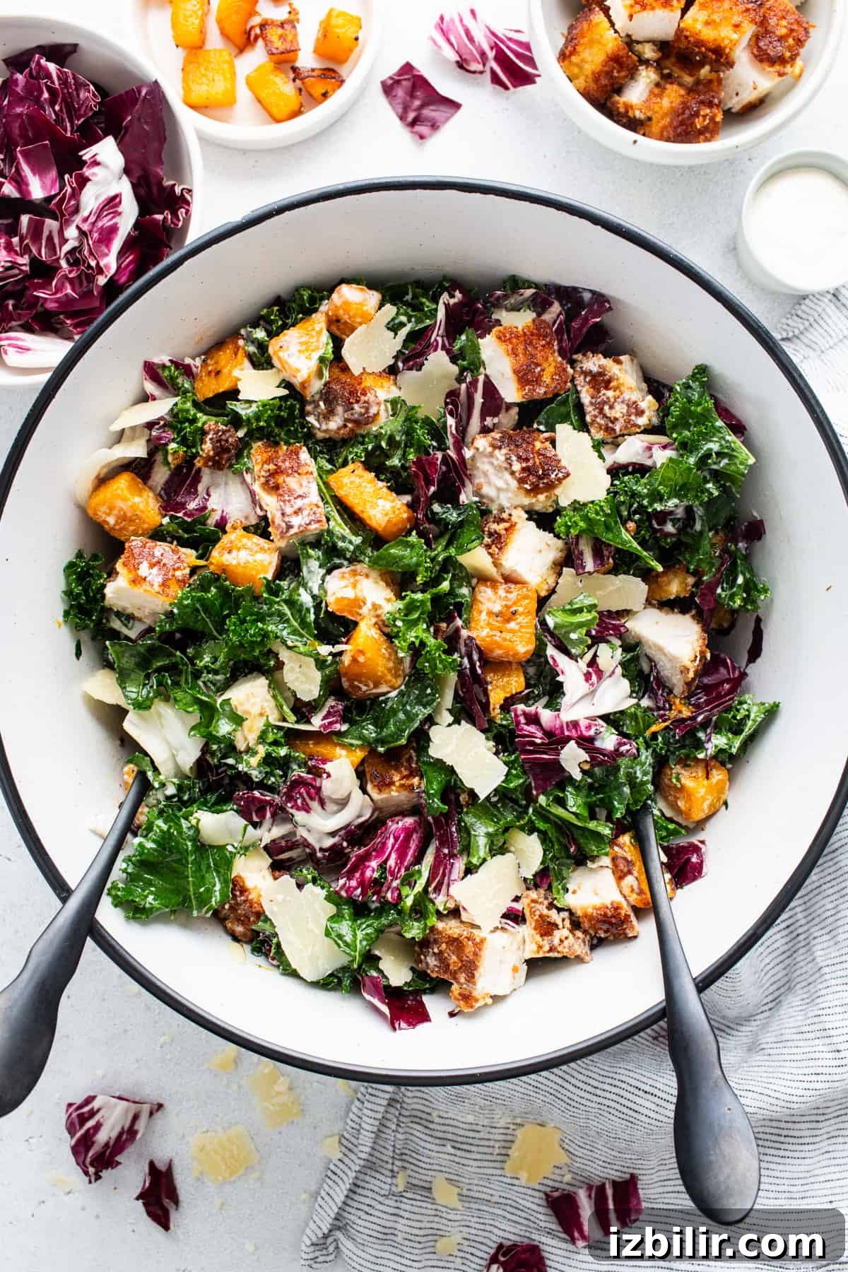 A bowl of kale salad with chicken and parmesan.