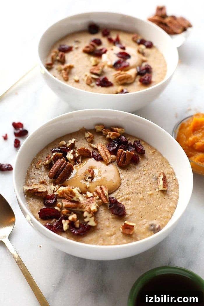 Creamy Spiced Pumpkin Oatmeal Recipe 4 Bowl of pumpkin oatmeal with pecans, cranberries and a drizzle of nut butter.