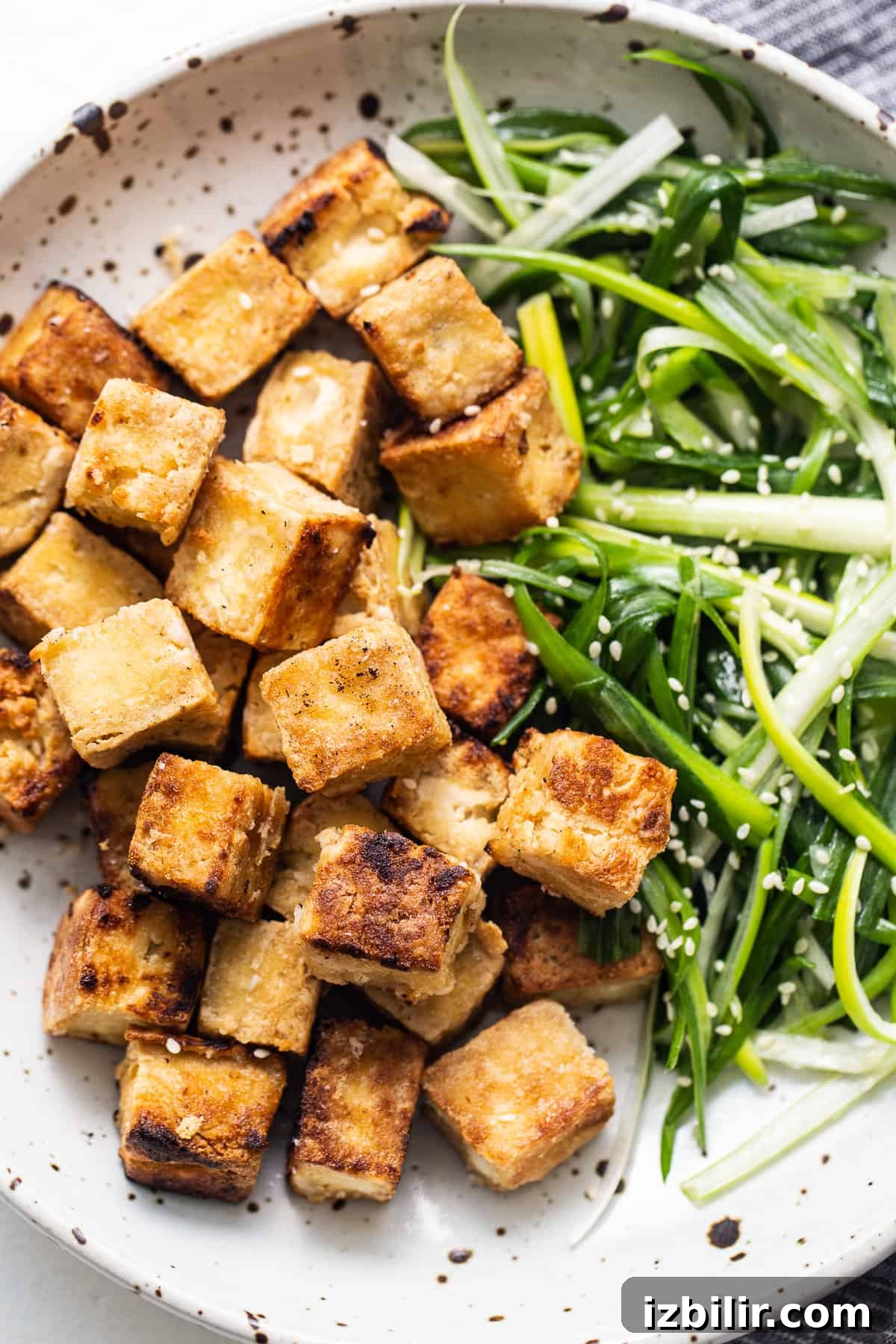 Tofu and greens on a plate.