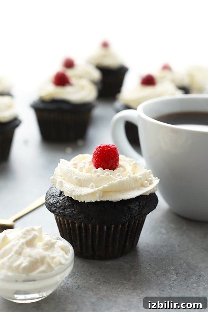 Healthier chocolate cupcakes topped with a fresh raspberry