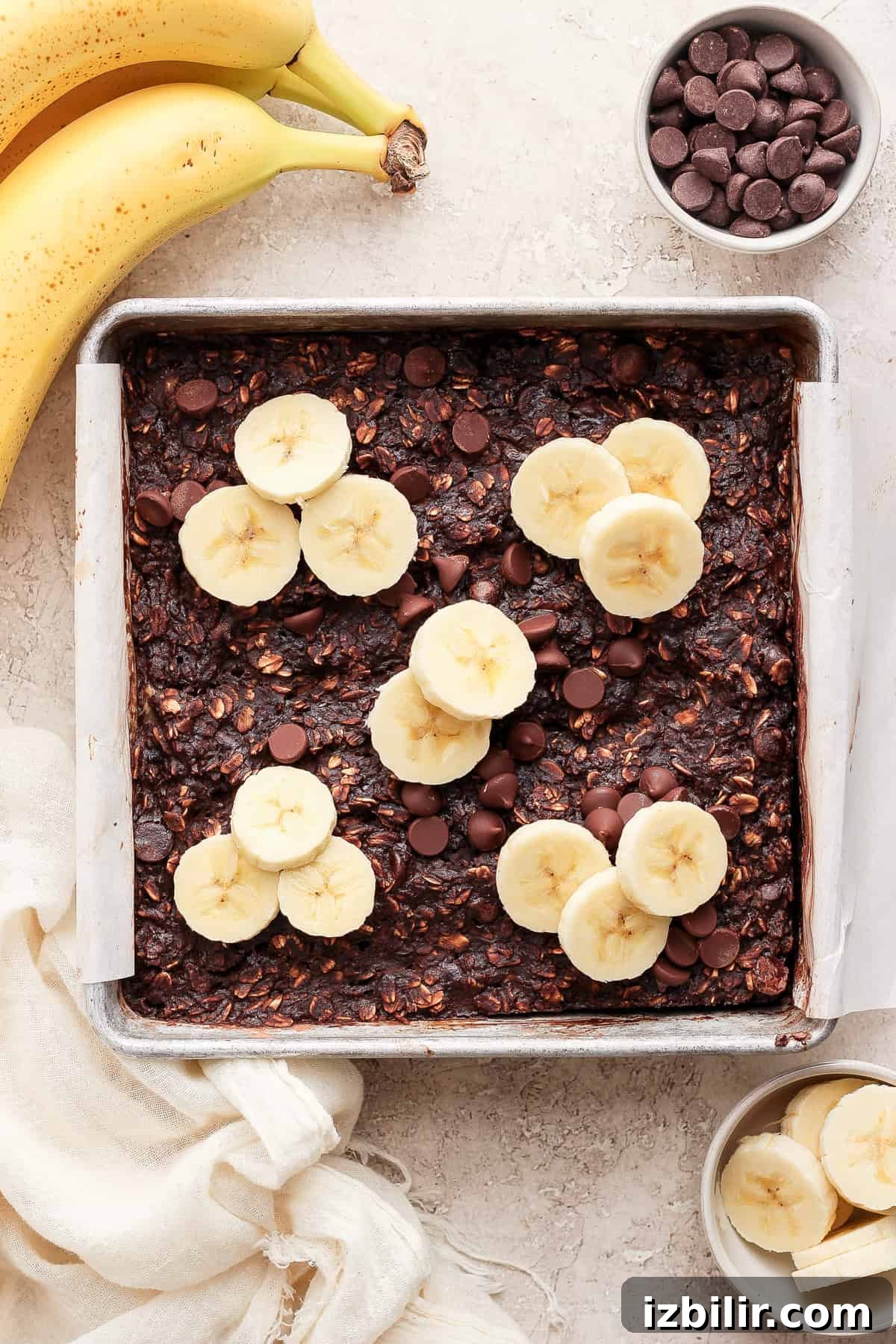A baking pan with banana slices and chocolate chips.