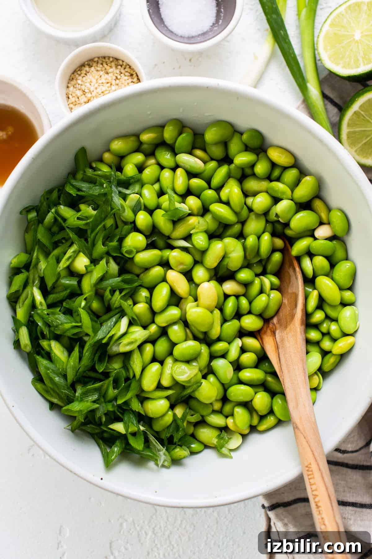Fit Foodie Cooking Club: Feb 2024 Recipes & Events 4 a white bowl filled with green beans and a wooden spoon.