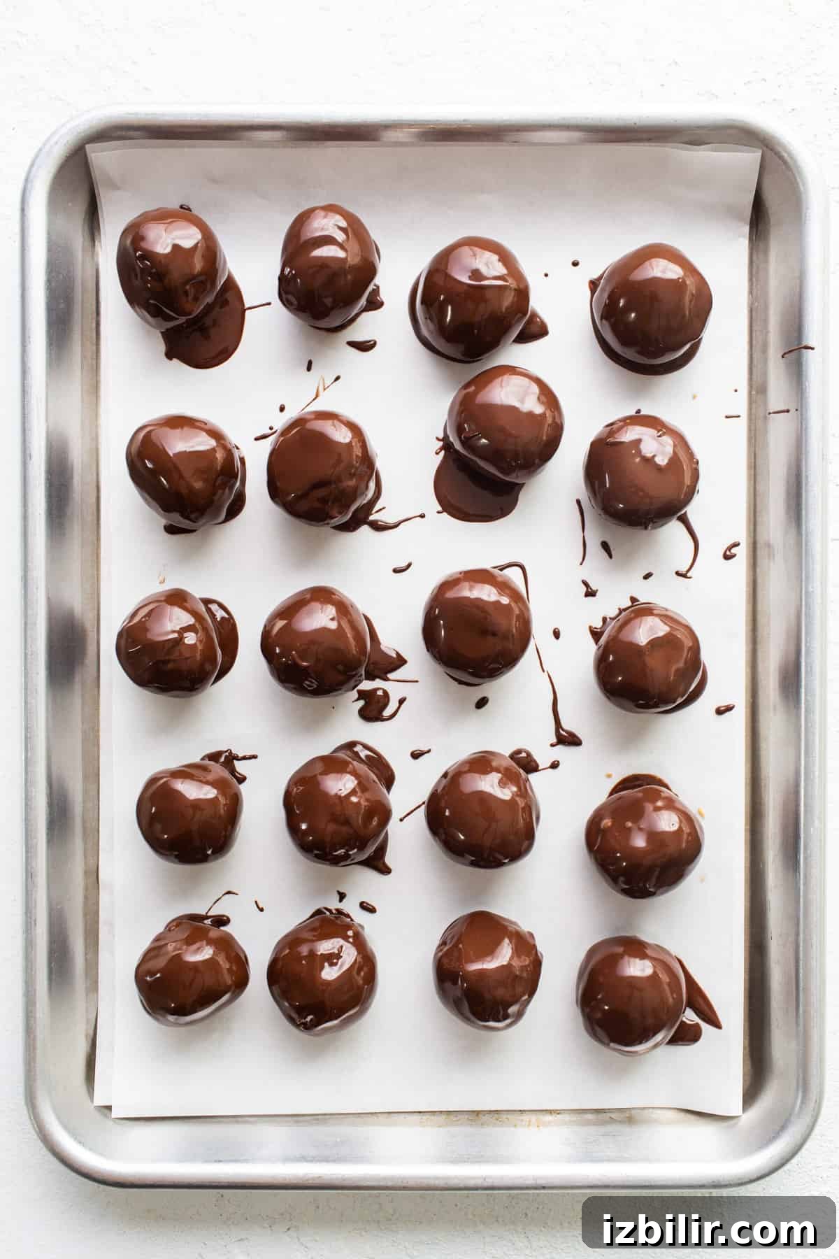 Chocolate covered peanuts on a baking sheet.