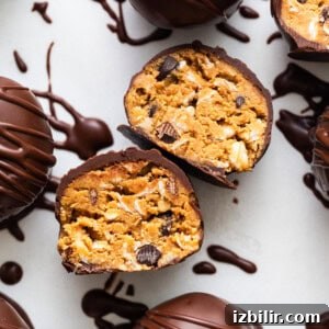 Chocolate covered peanut butter truffles on a white surface.