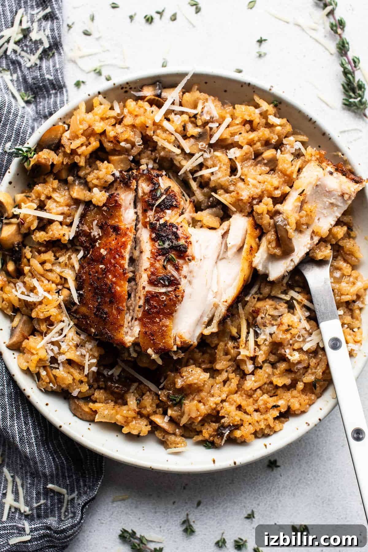 One-Pot Creamy Mushroom Chicken and Rice Recipe 2 Chicken risotto with mushrooms and thyme on a plate.