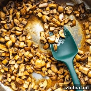 Mushrooms sautéing in a pan.