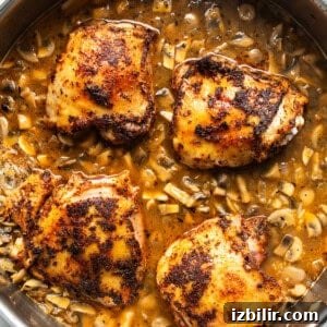 Chicken placed on top of rice in a skillet.