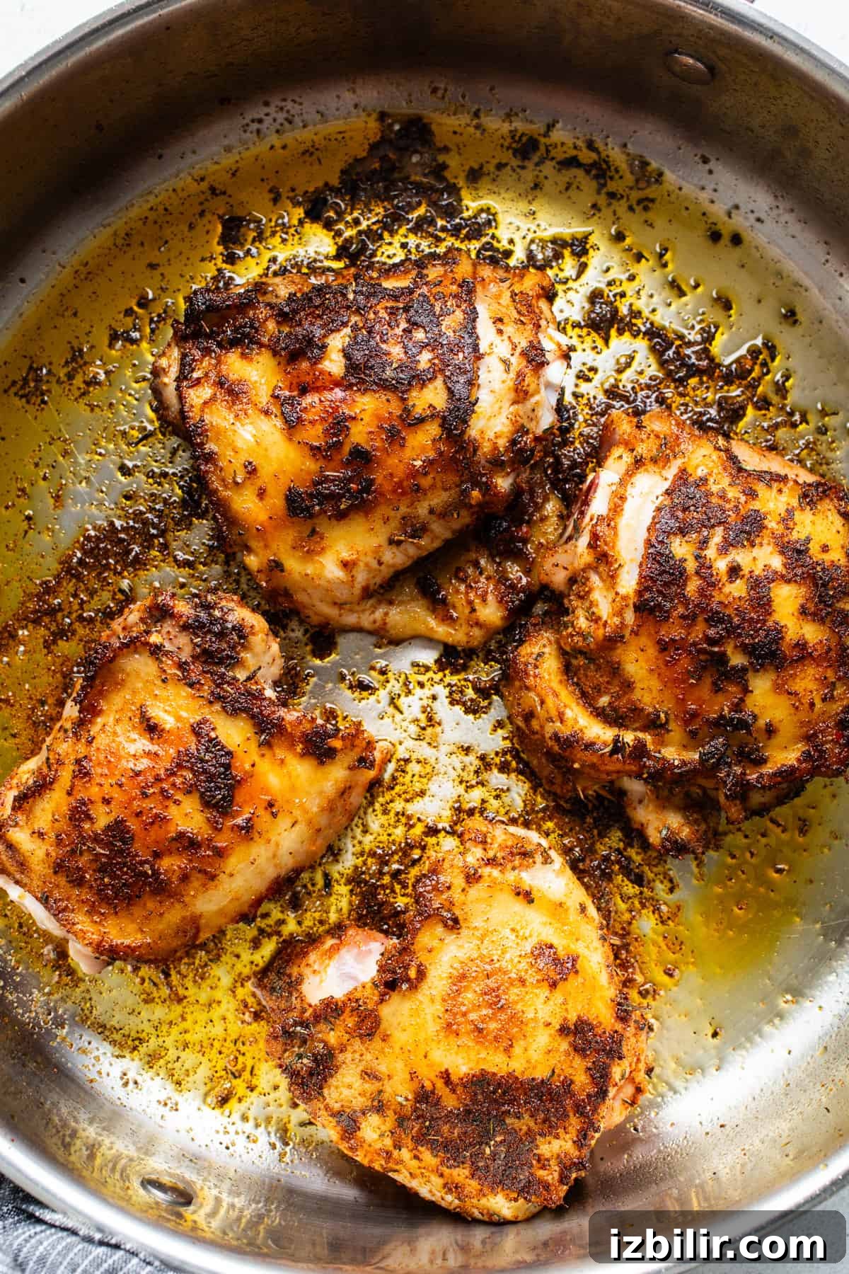 One-Pot Creamy Mushroom Chicken and Rice Recipe 3 Roasted chicken in a skillet on a white background.