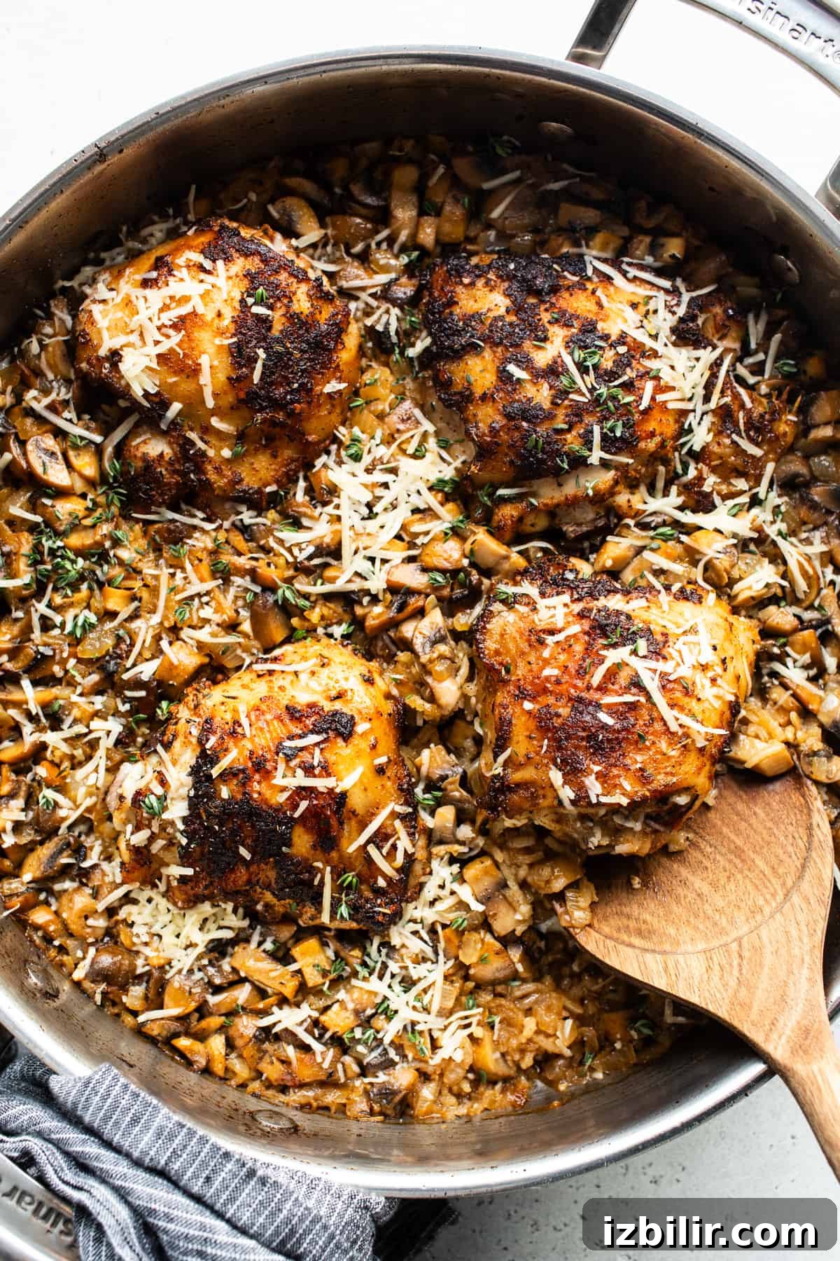 One-Pot Creamy Mushroom Chicken and Rice Recipe 5 A pan with chicken and mushrooms in it.