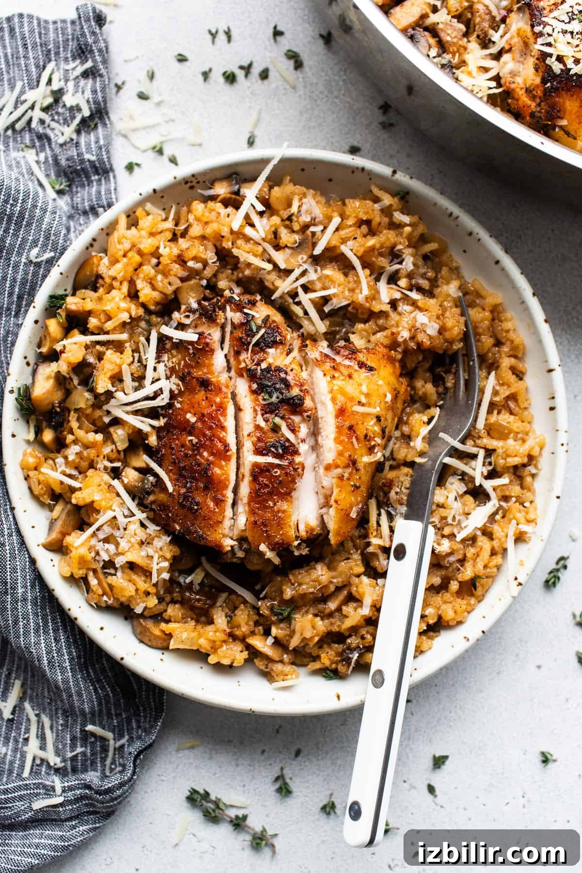 One-Pot Creamy Mushroom Chicken and Rice Recipe 6 Chicken and rice in a white plate with a fork.